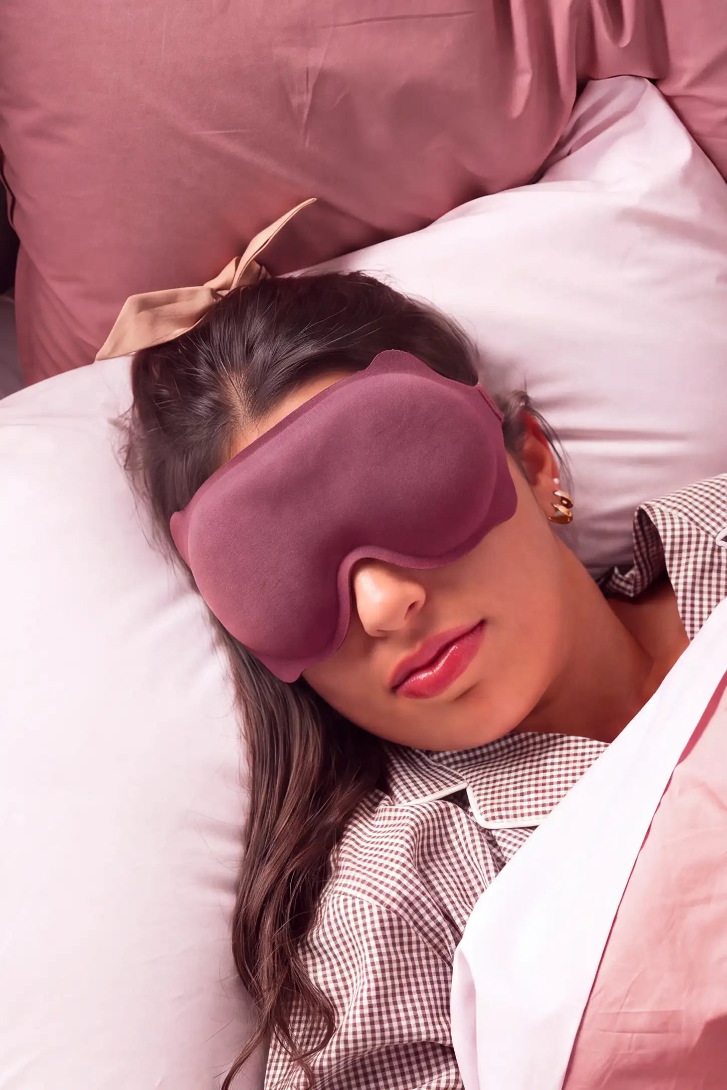 3D Contoured Blackout Sleep Mask 3D Contoured Blackout Sleep Mask in Soft Pink featuring 3D ergonomic contoured design, soft lightweight breathable fabric, total light blocking performance, and an adjustable strap worn by a woman resting in bed, lifestyle view.
