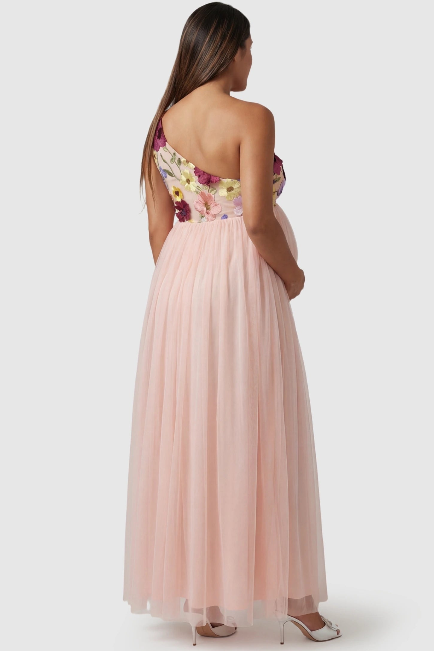 3D Floral One-Shoulder Maternity Gown 3D Floral One-Shoulder Maternity Gown in Pink featuring an asymmetric shoulder and flowy tulle on a pregnant model.