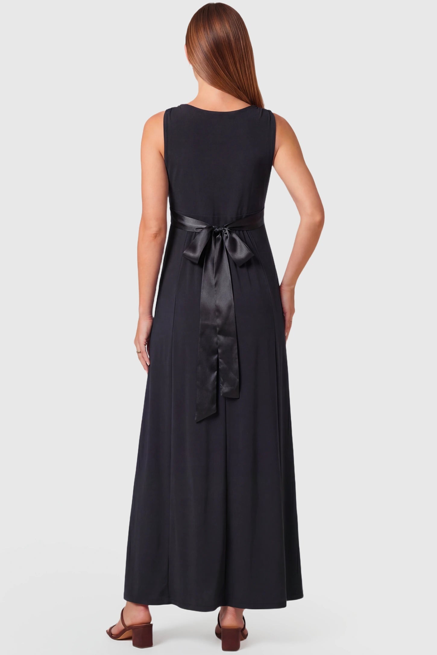 Sleeveless Faux Wrap Maternity & Nursing Maxi Dress Sleeveless Faux Wrap Maternity & Nursing Maxi Dress in black featuring bow tie and empire waist on a pregnant model.