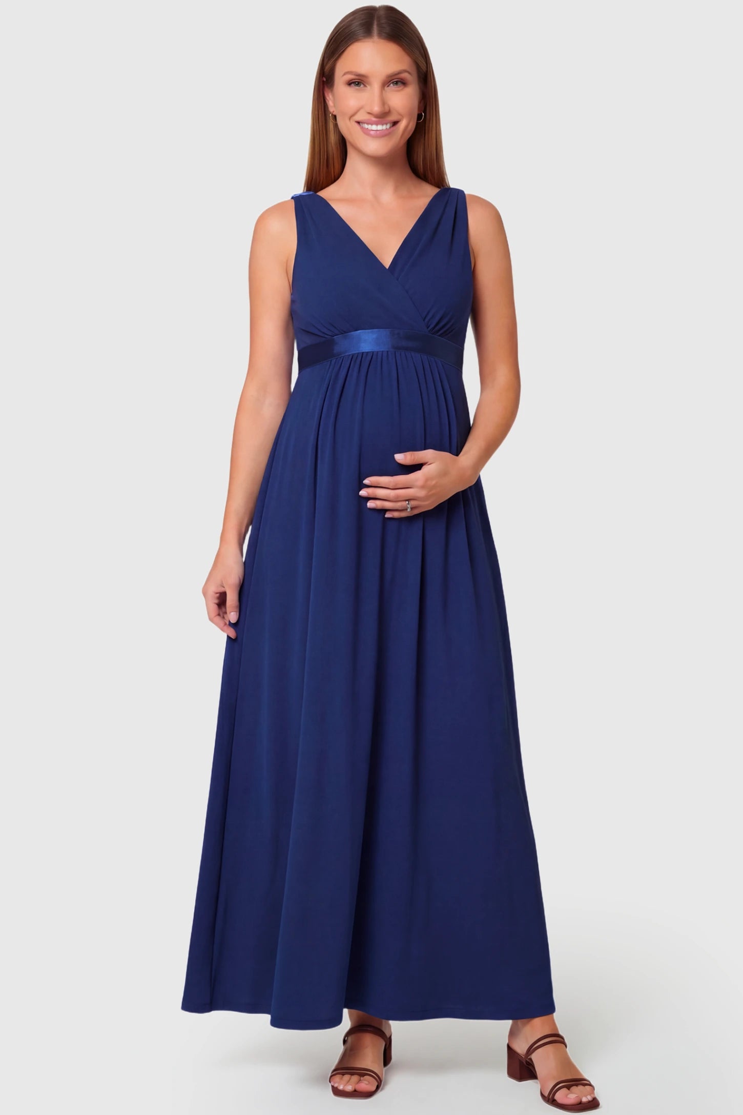 Sleeveless Faux Wrap Maternity & Nursing Maxi Dress Sleeveless Faux Wrap Maternity & Nursing Maxi Dress in dark blue featuring V-neckline and empire waist on a pregnant model.