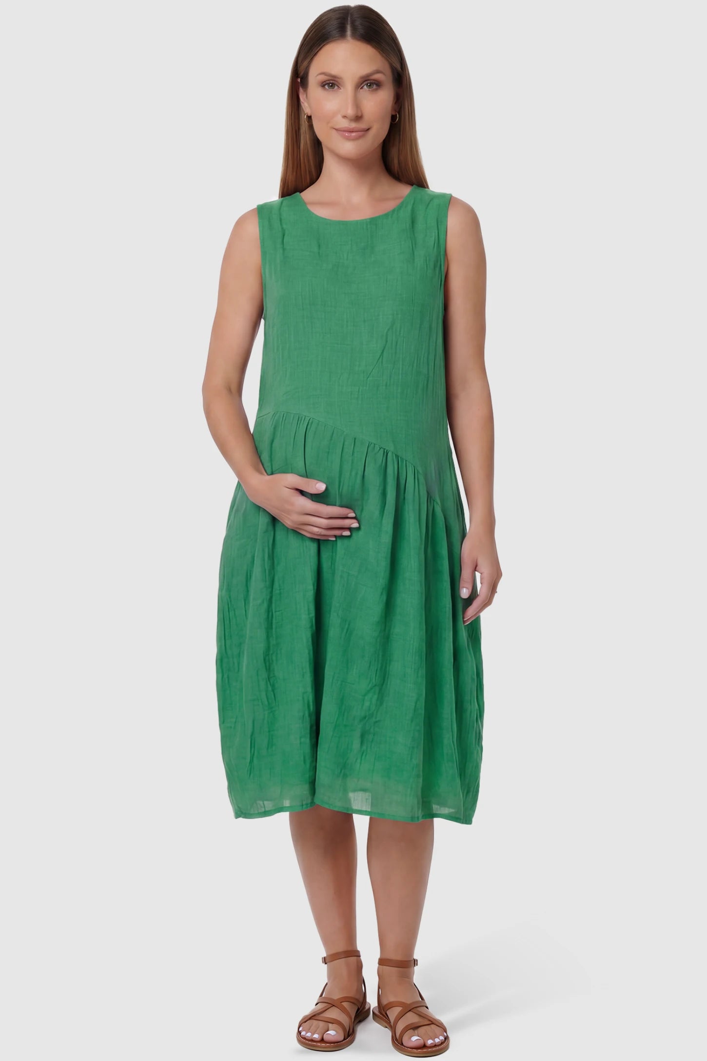 Sleeveless Pocketed A-Line Maternity Midi Dress Sleeveless pocketed A-line maternity midi dress in green with sleeveless cut, front view on pregnant model