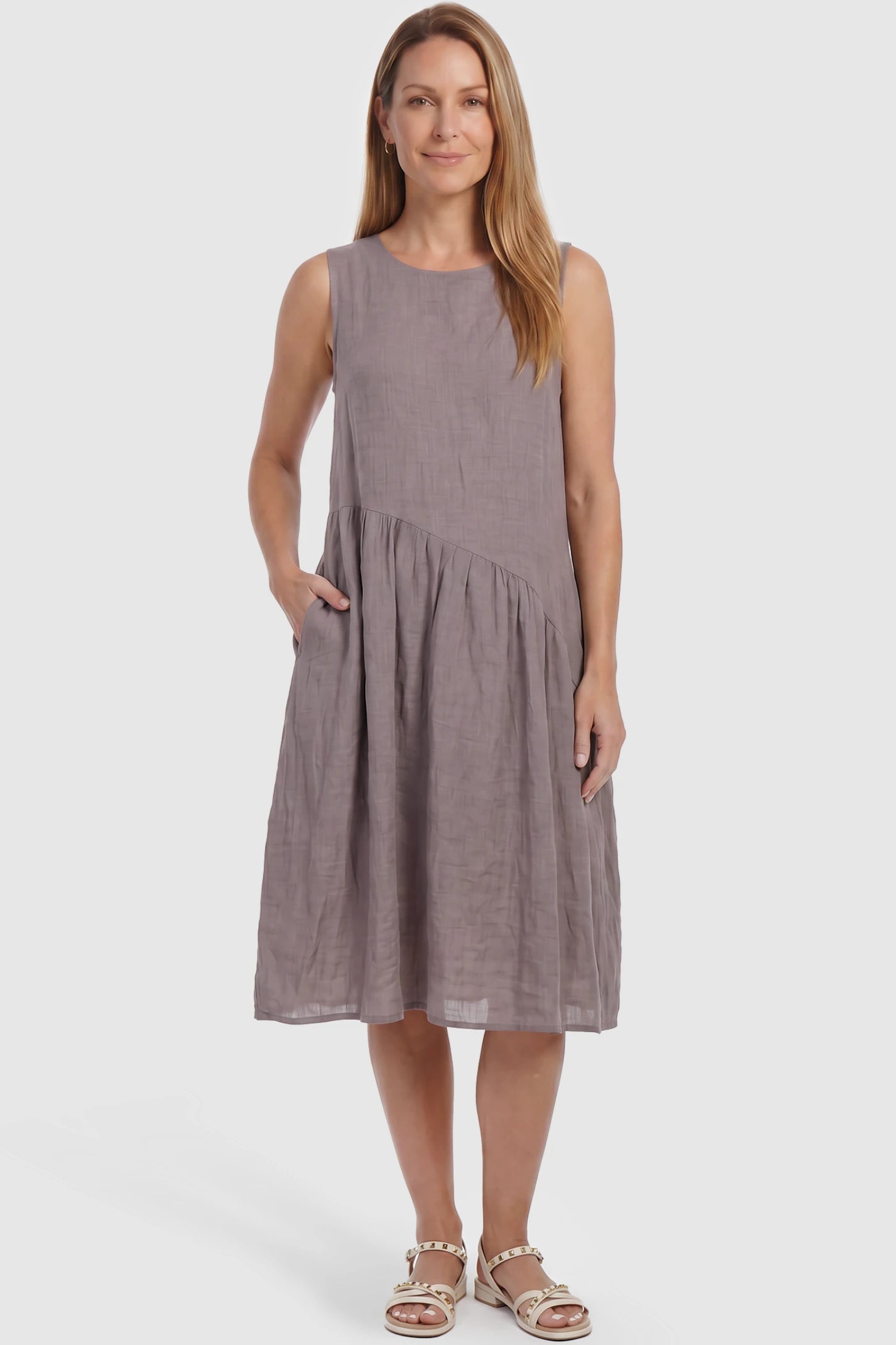 Sleeveless Pocketed A-Line Maternity Midi Dress Sleeveless pocketed A-line maternity midi dress in light taupe with sleeveless cut, front view on postpartum model