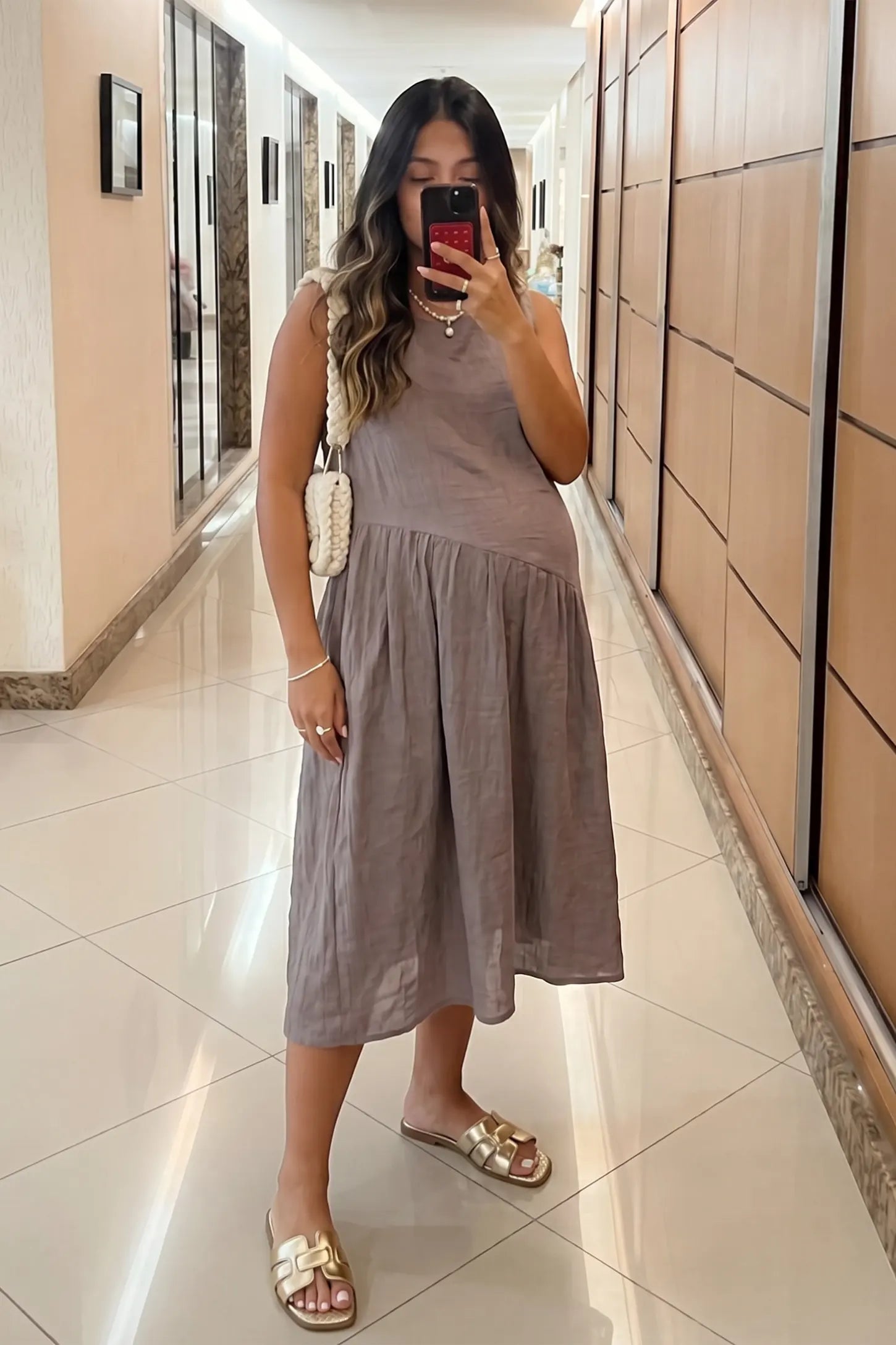 Sleeveless Pocketed A-Line Maternity Midi Dress Sleeveless pocketed A-line maternity midi dress in light taupe with sleeveless cut, front view on pregnant model