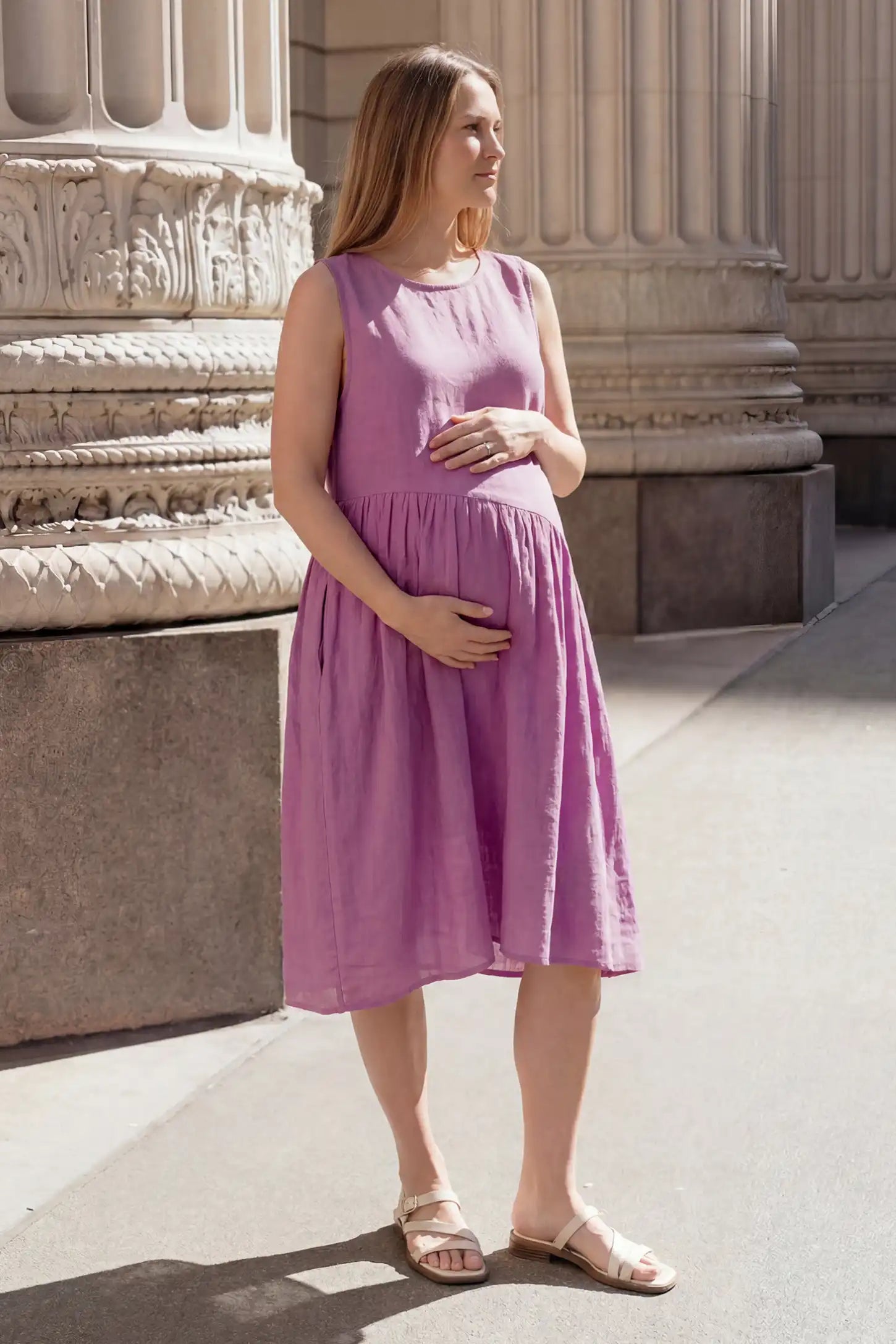 Sleeveless Pocketed A-Line Maternity Midi Dress Sleeveless pocketed A-line maternity midi dress in pink with sleeveless cut, front view on pregnant model