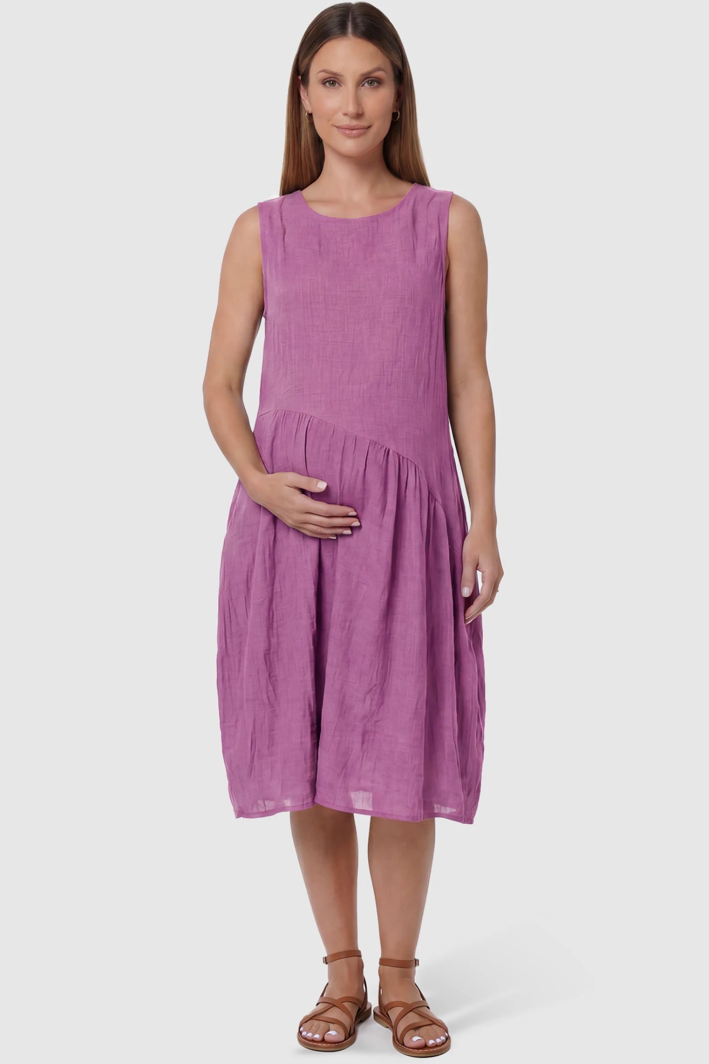 Sleeveless Pocketed A-Line Maternity Midi Dress Sleeveless pocketed A-line maternity midi dress in pink with sleeveless cut, front view on pregnant model