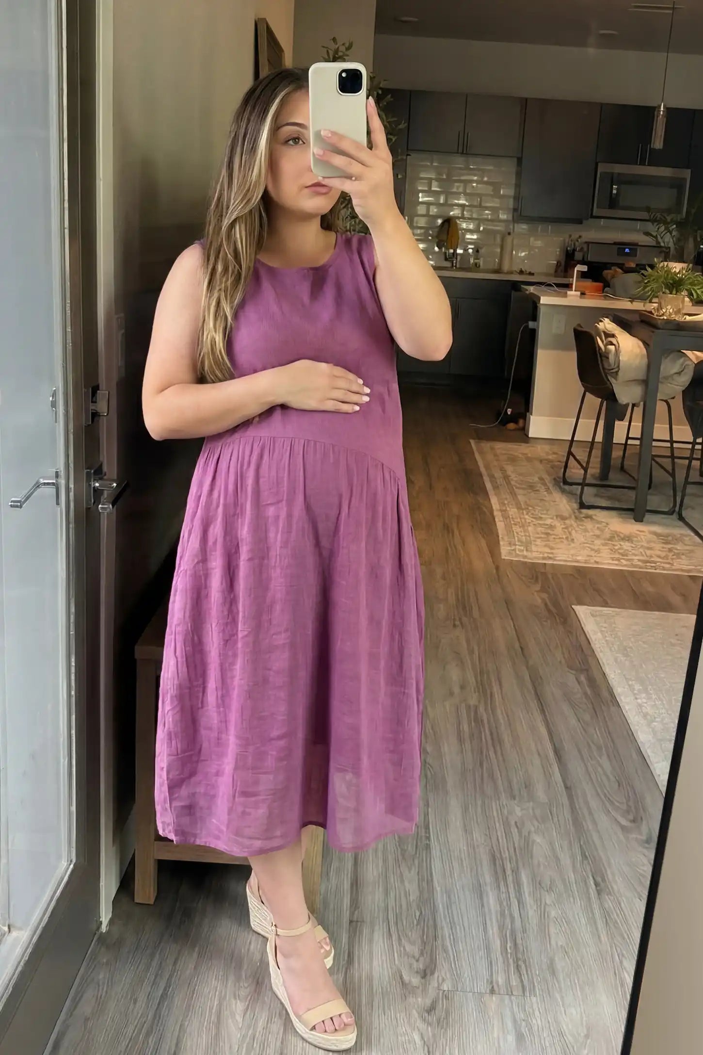 Sleeveless Pocketed A-Line Maternity Midi Dress Sleeveless pocketed A-line maternity midi dress in pink with sleeveless cut, front view on pregnant model