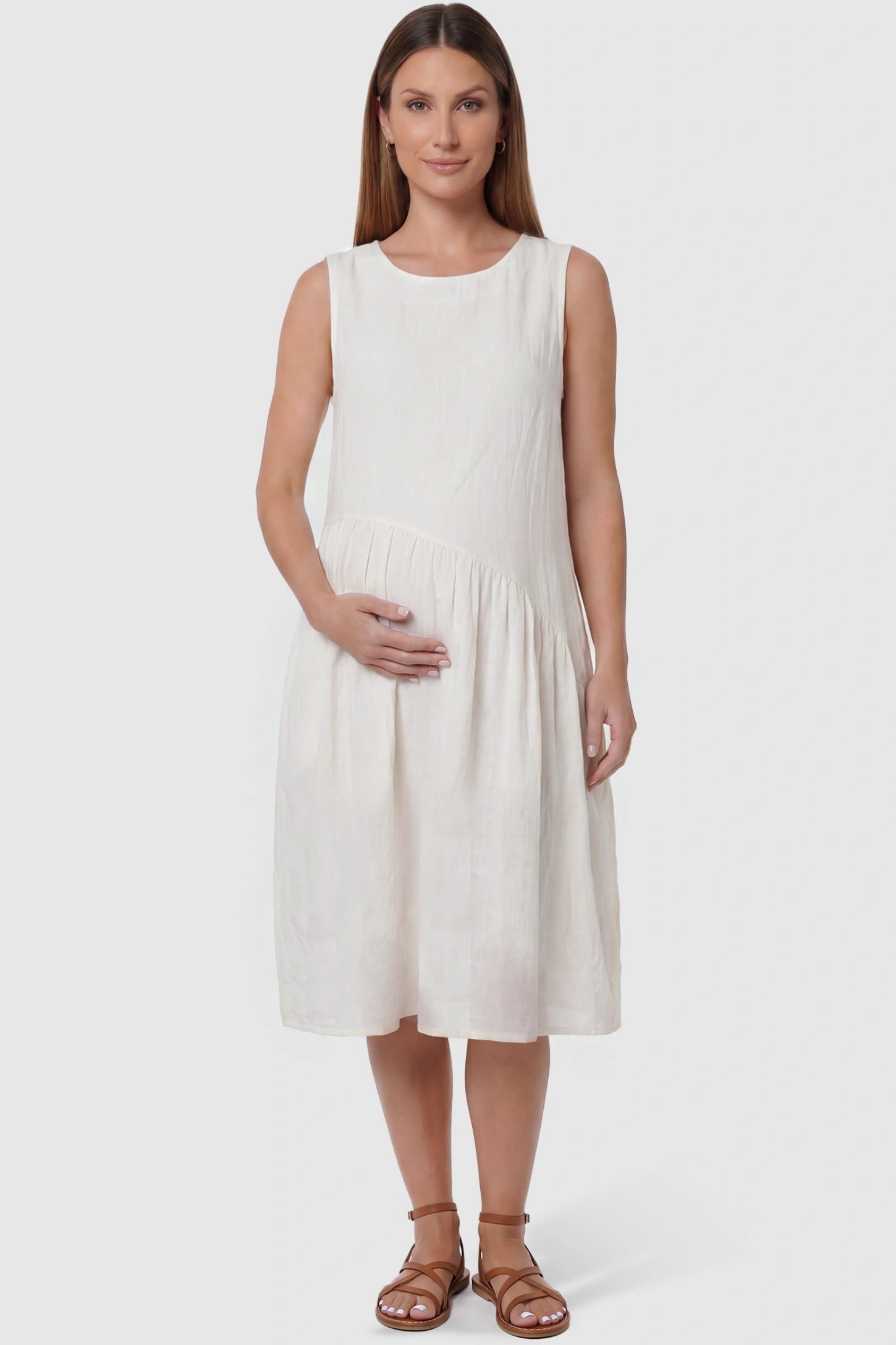 Sleeveless pocketed A-line maternity midi dress in white with sleeveless cut, front view on pregnant model