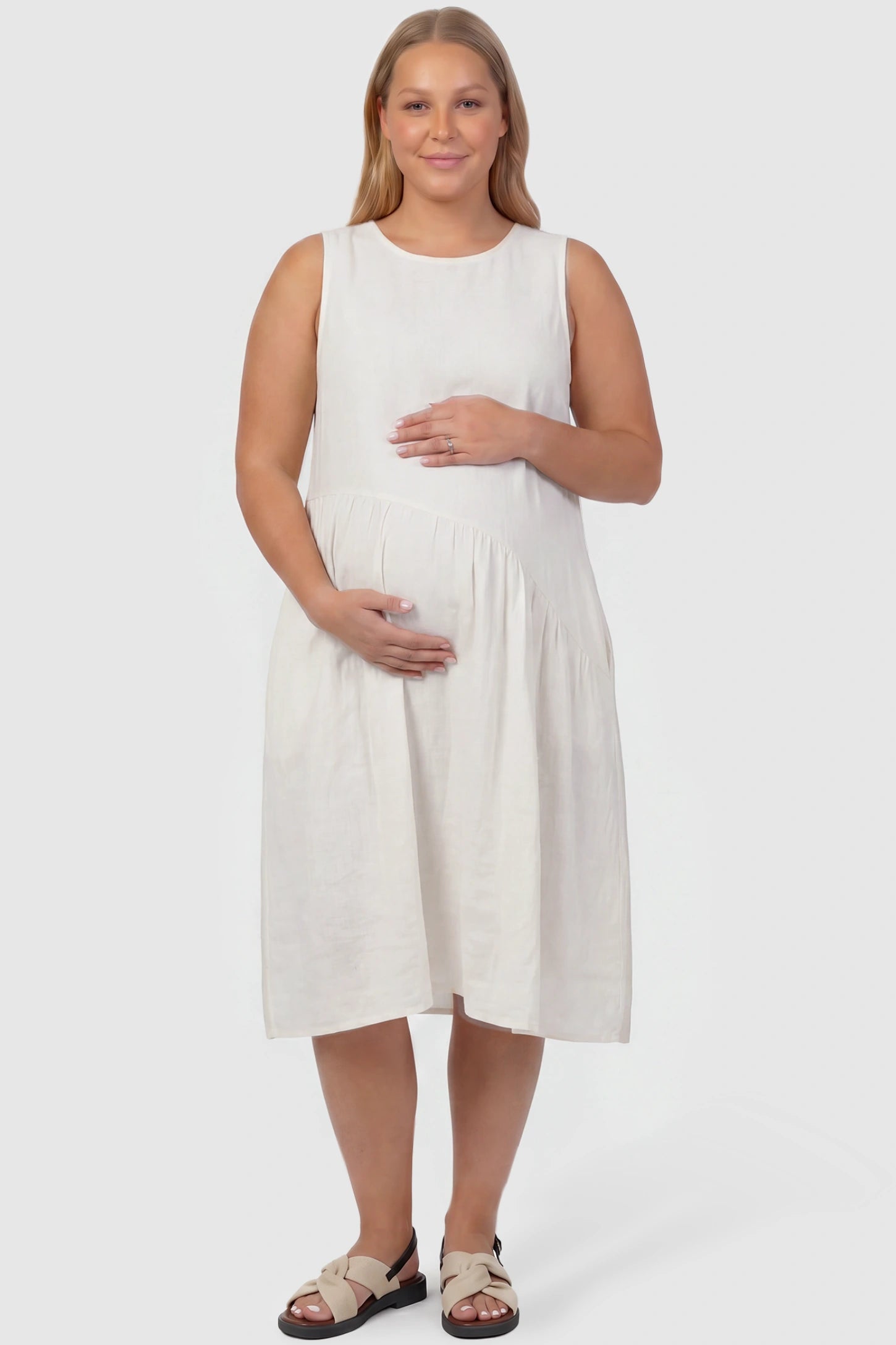 Sleeveless Pocketed A-Line Maternity Midi Dress Sleeveless pocketed A-line maternity midi dress in white with sleeveless cut, front view on plus-size model