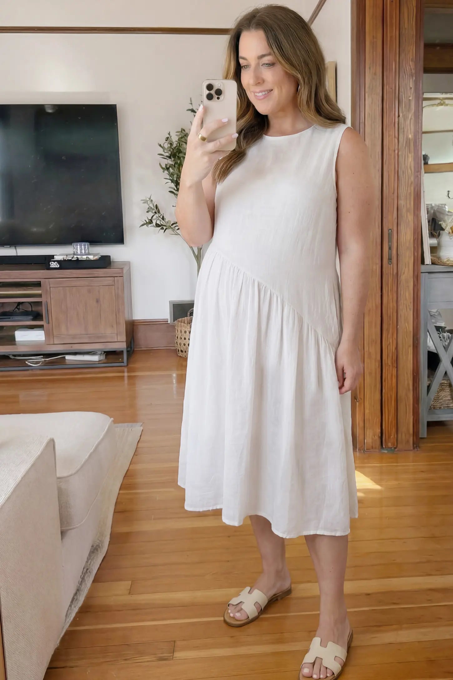 Sleeveless Pocketed A-Line Maternity Midi Dress Sleeveless pocketed A-line maternity midi dress in white with sleeveless cut, front view on pregnant model