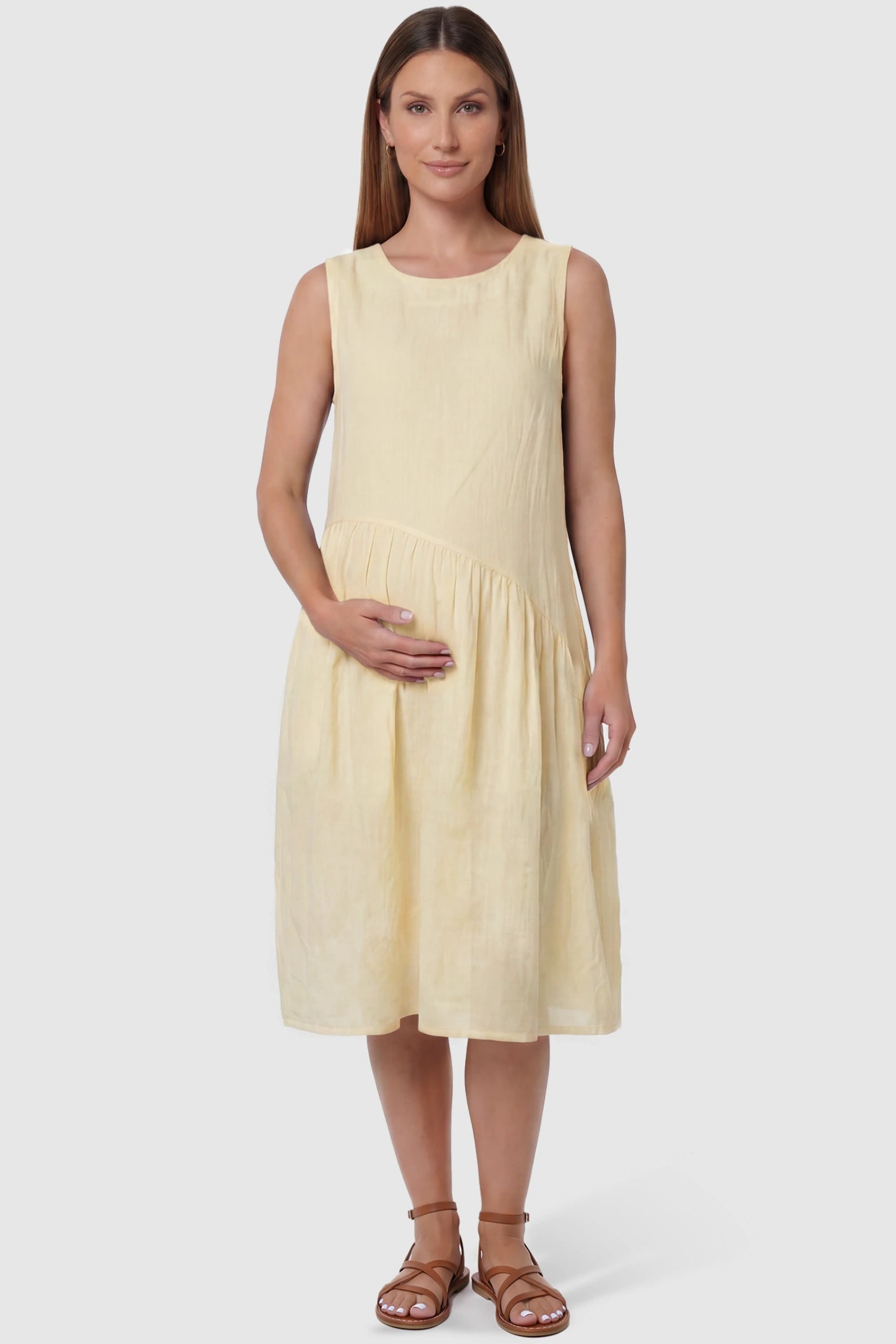 Sleeveless Pocketed A-Line Maternity Midi Dress Sleeveless pocketed A-line maternity midi dress in yellow with sleeveless cut, front view on pregnant model