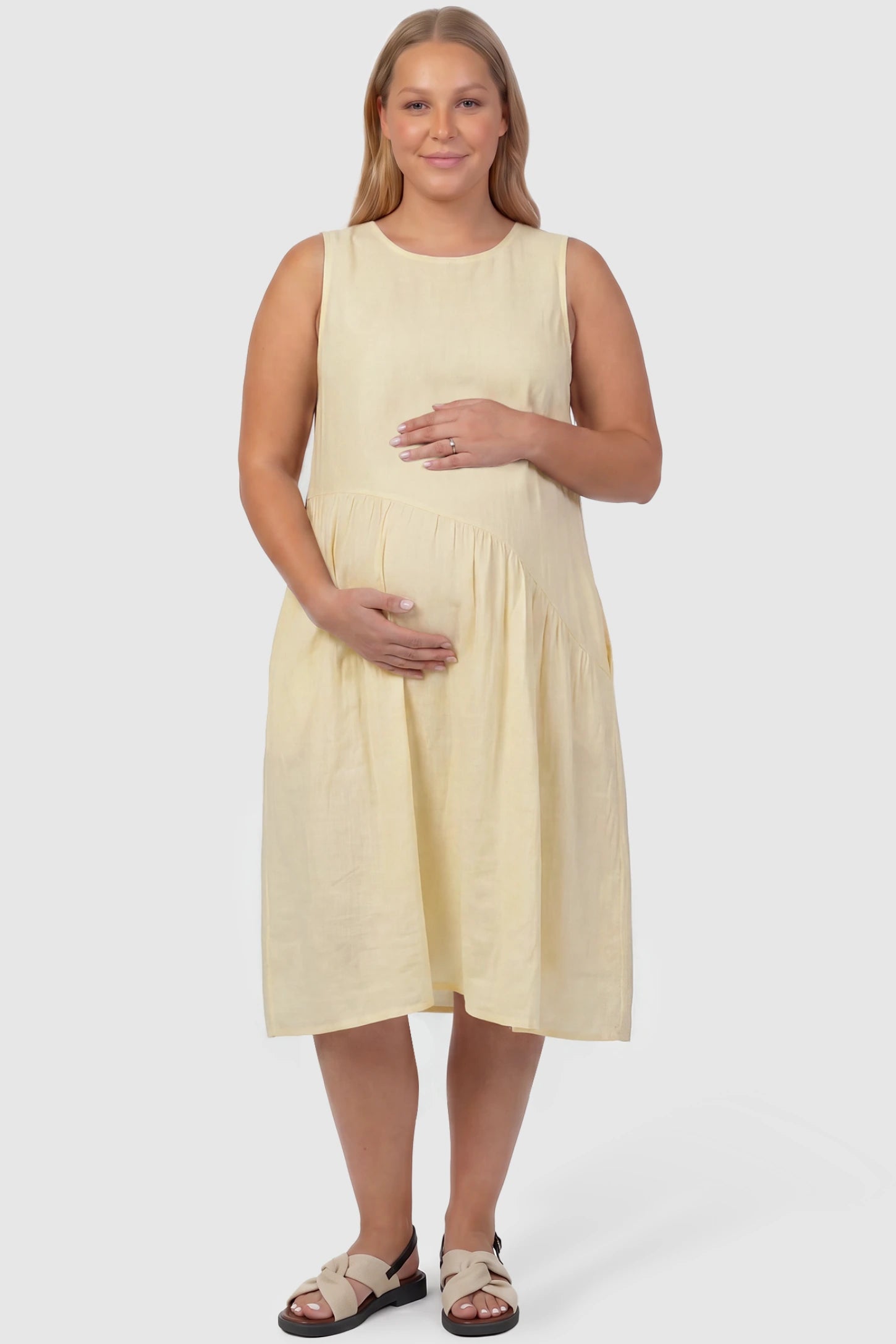 Sleeveless Pocketed A-Line Maternity Midi Dress Sleeveless pocketed A-line maternity midi dress in yellow with sleeveless cut, front view on plus-size model