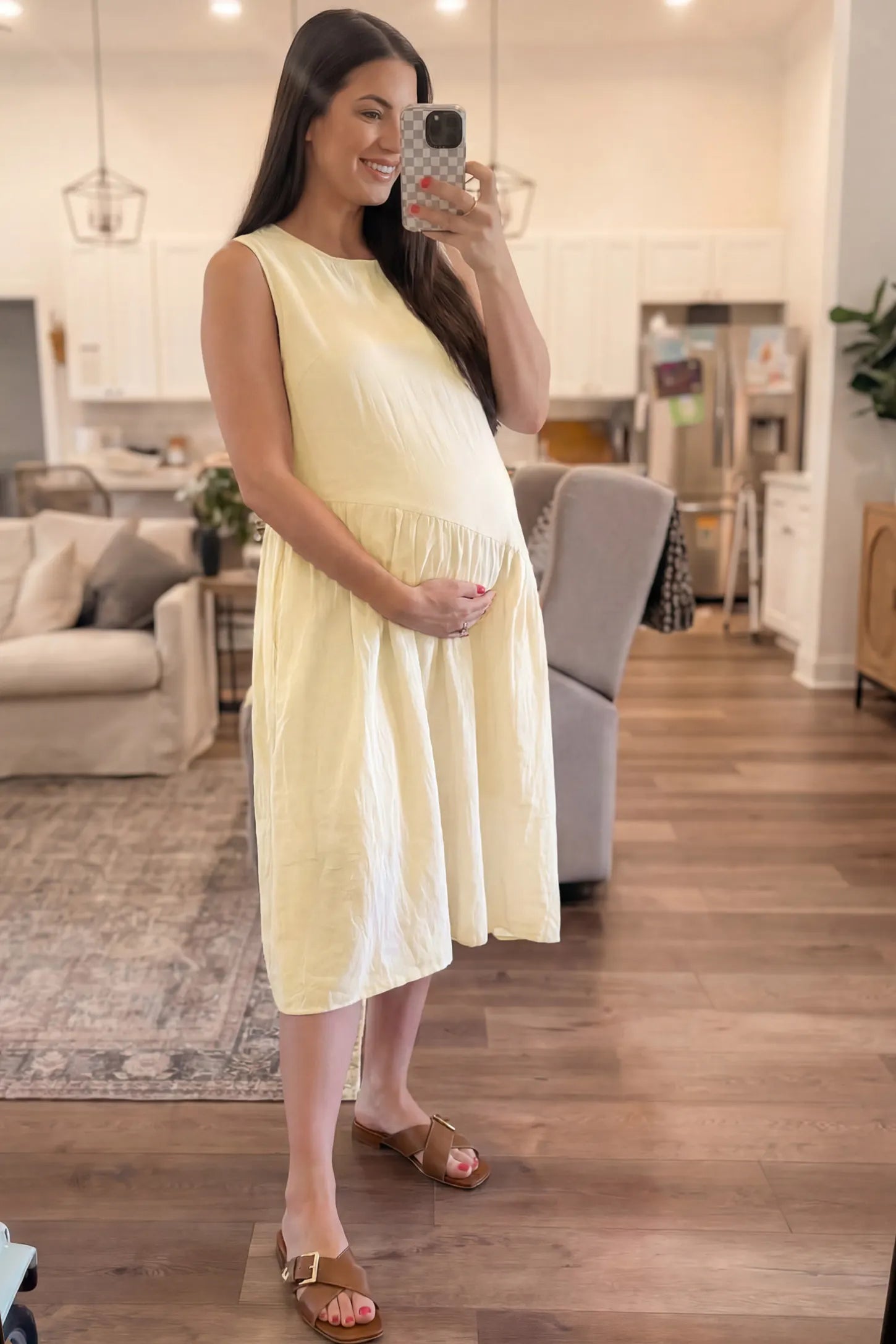 Sleeveless Pocketed A-Line Maternity Midi Dress Sleeveless pocketed A-line maternity midi dress in yellow with sleeveless cut, front view on pregnant model