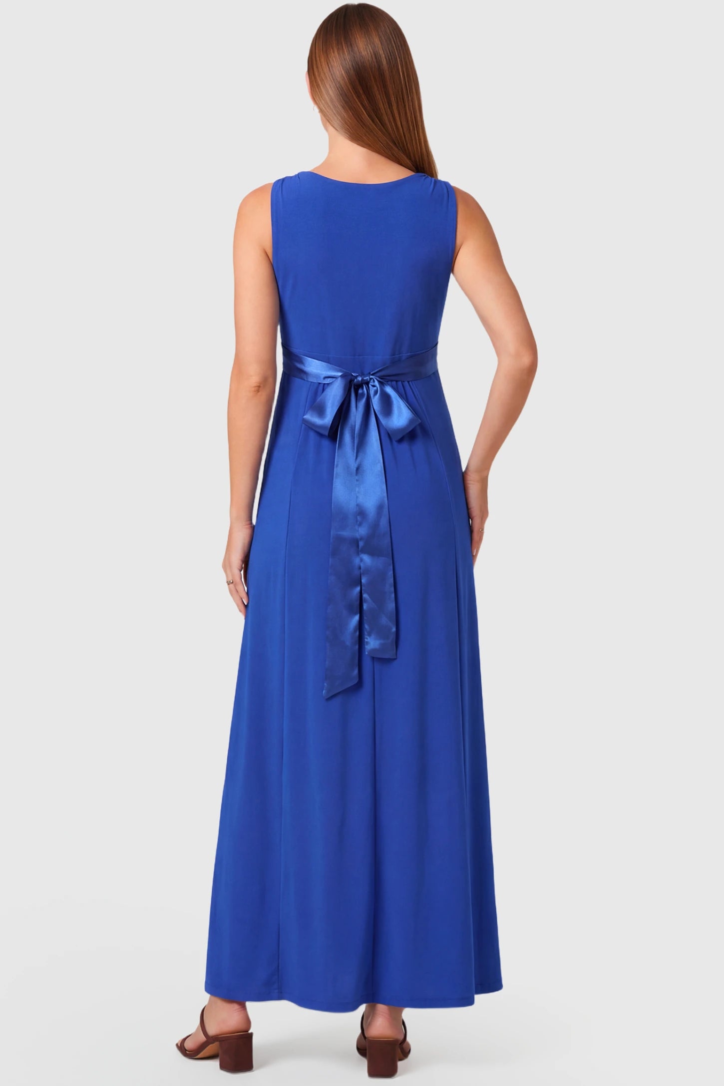 Sleeveless Faux Wrap Maternity & Nursing Maxi Dress Sleeveless Faux Wrap Maternity & Nursing Maxi Dress in royal blue featuring bow tie and empire waist on a pregnant model.