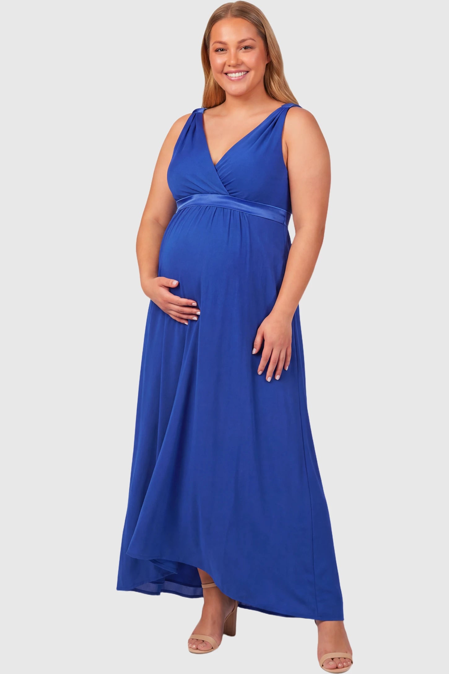 Sleeveless Faux Wrap Maternity & Nursing Maxi Dress Sleeveless Faux Wrap Maternity & Nursing Maxi Dress in royal blue featuring V-neckline and empire waist on a plus size pregnant model.