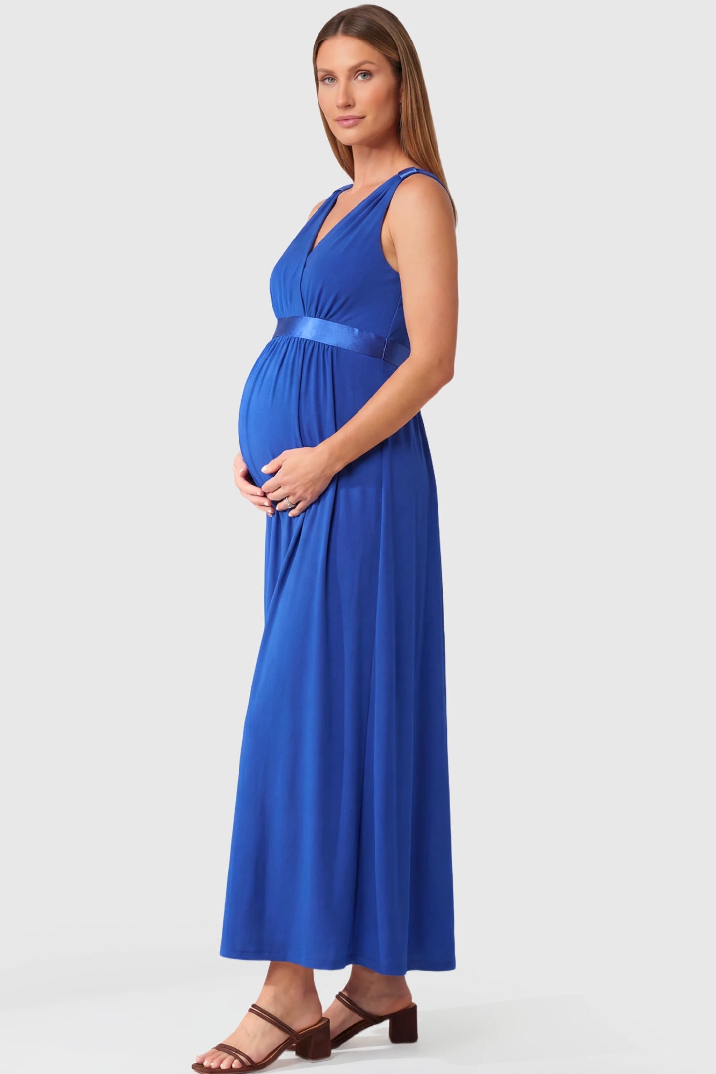 Sleeveless Faux Wrap Maternity & Nursing Maxi Dress in royal blue featuring V-neckline and empire waist on a pregnant model.