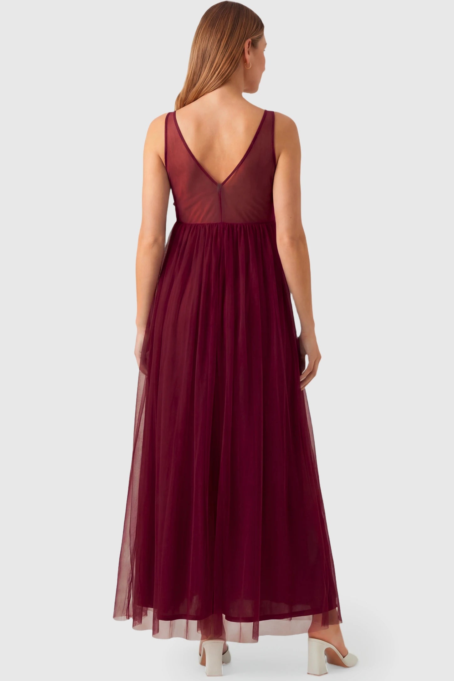 Sleeveless A-line Maternity Gown Sleeveless A-line Maternity Gown in wine red featuring lace-trimmed V-neck and empire waist on pregnant model.