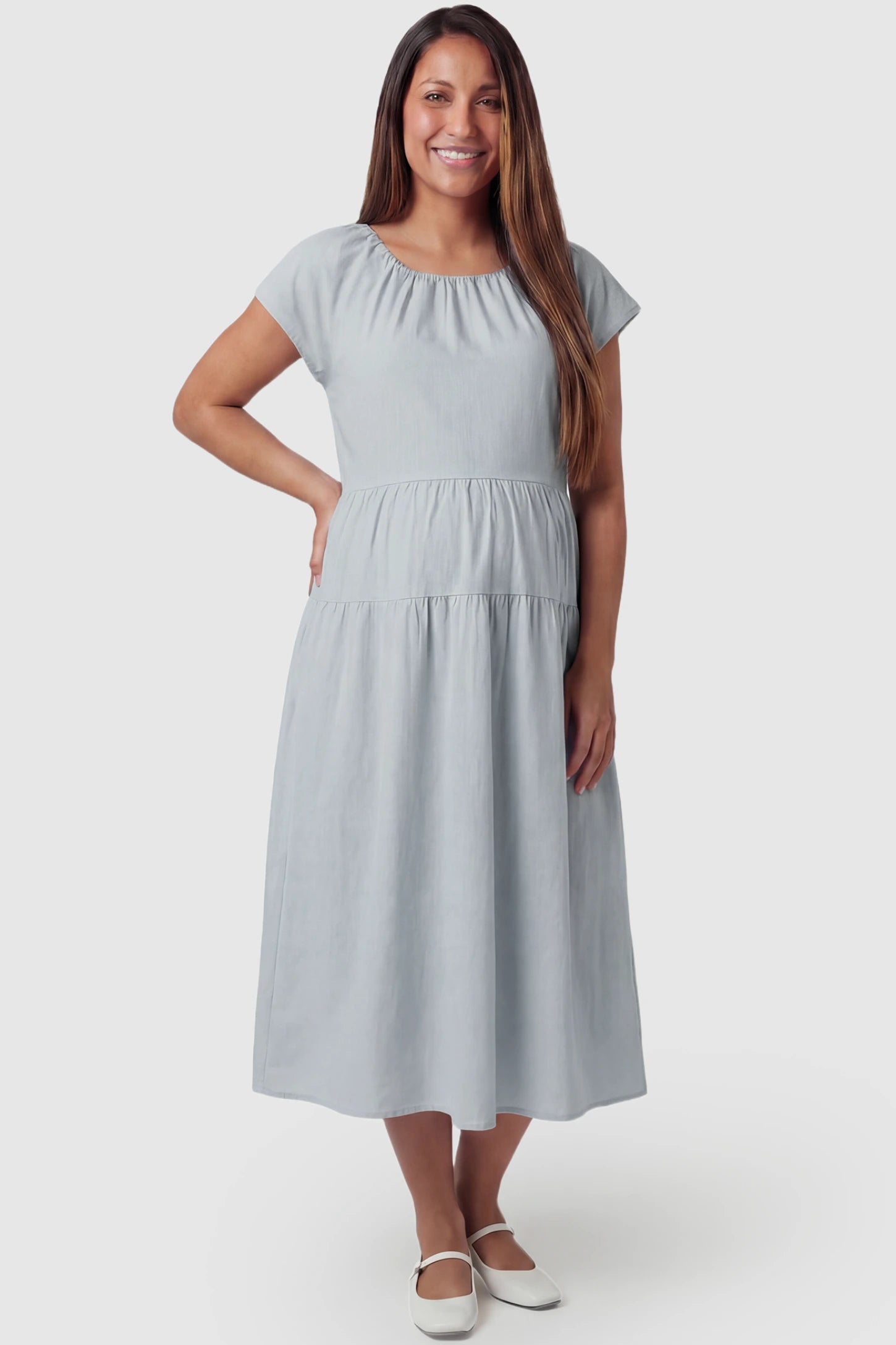 Adjustable waist-tie A-line maternity midi dress in blue with flowy A-line silhouette, front view on pregnant model