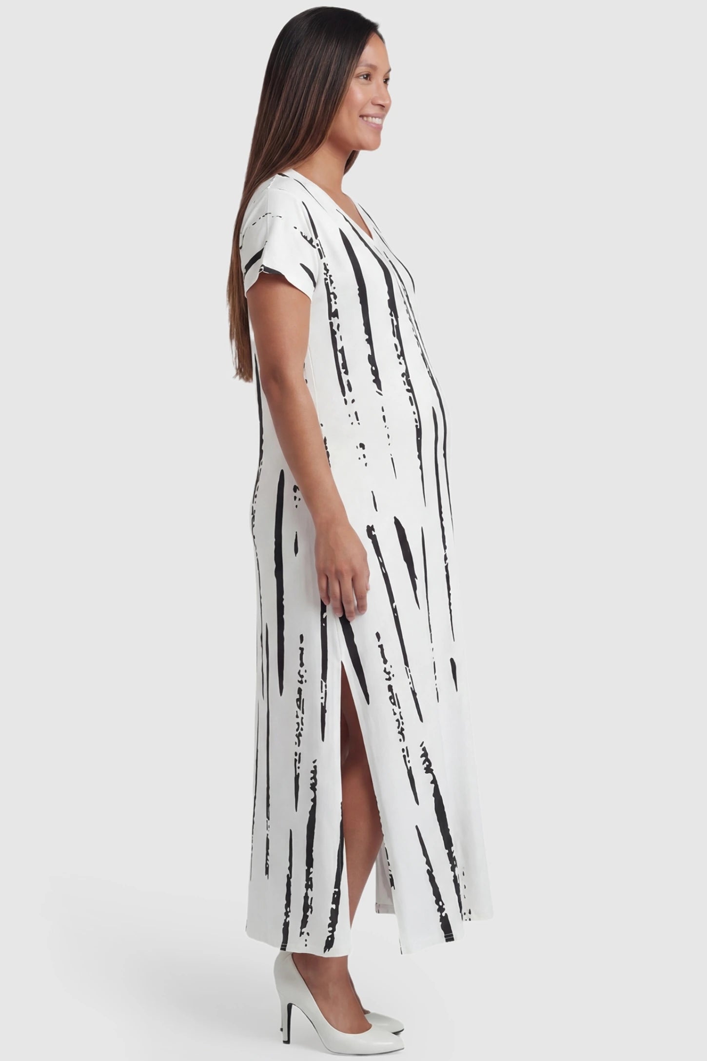Abstract Stripe V-Neck Maxi Maternity Dress in Black Stripe featuring short sleeves and a 3D pattern on a pregnant model, side view.