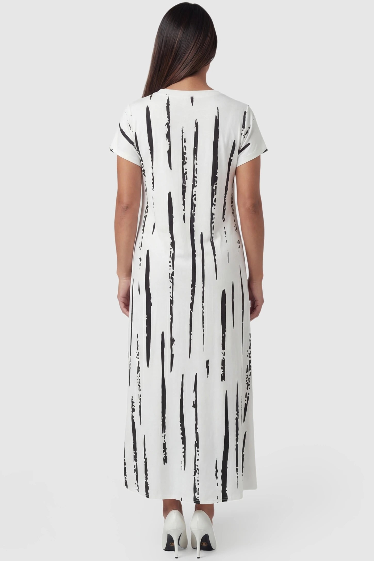 Abstract Stripe V-Neck Maxi Maternity Dress bstract Stripe V-Neck Maxi Maternity Dress in Black Stripe featuring a relaxed, flowy silhouette on a pregnant model, back view.