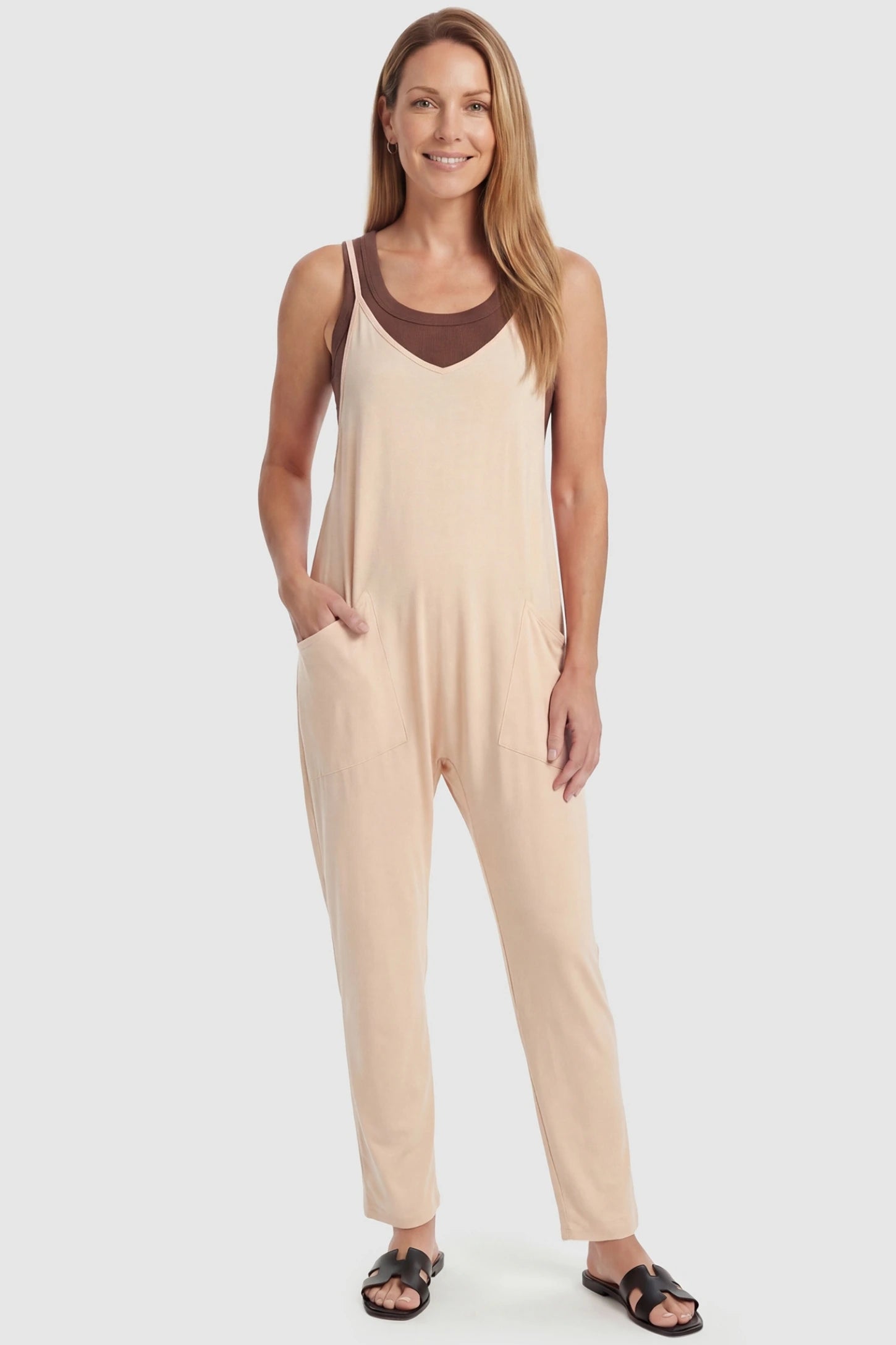 Adjustable Strap Pocketed Relaxed Maternity Jumpsuit Adjustable Strap Relaxed Maternity Jumpsuit in Beige featuring a loose fit and functional pockets on a non-pregnant model.