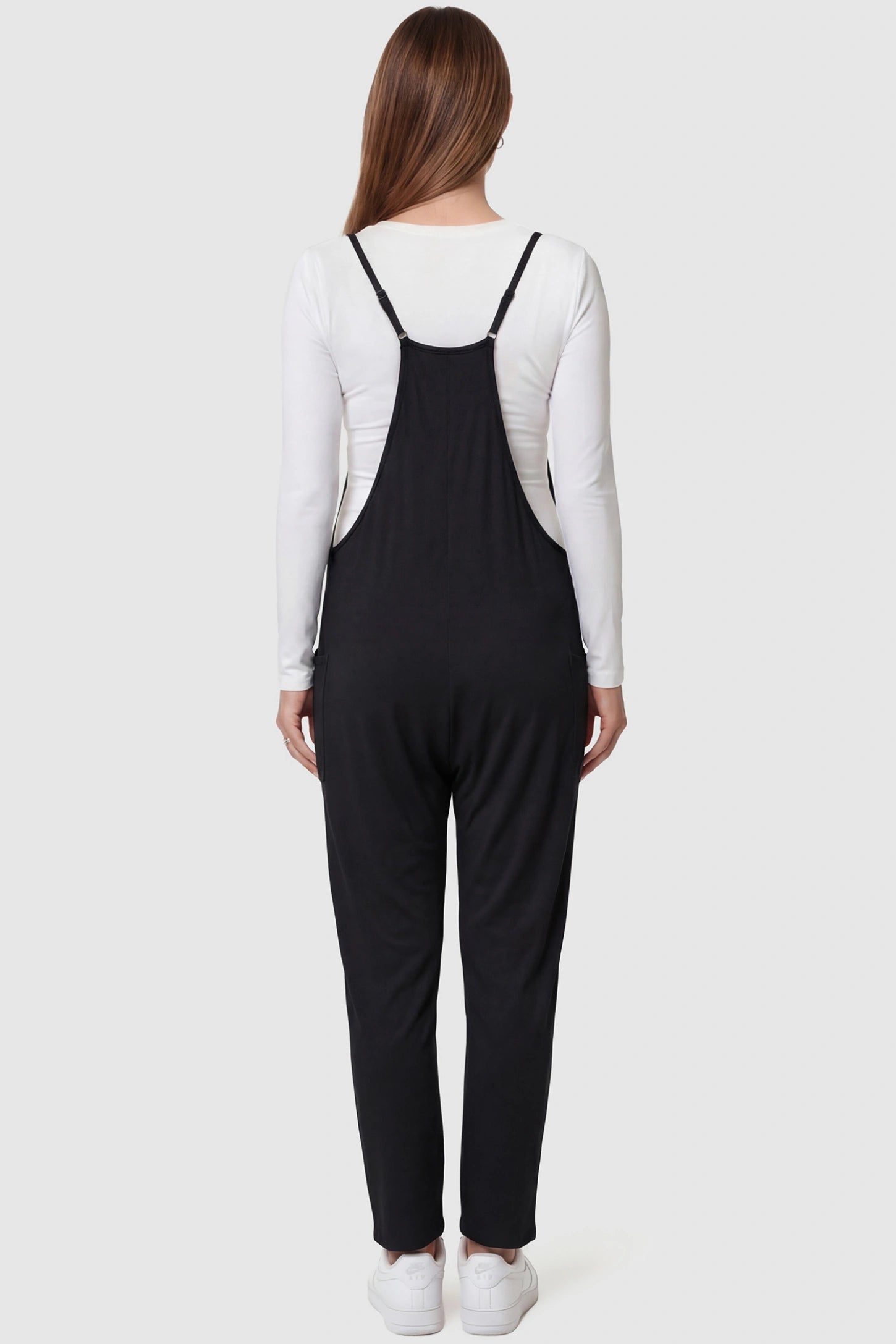 Adjustable Strap Pocketed Relaxed Maternity Jumpsuit Adjustable Strap Relaxed Maternity Jumpsuit in Black featuring a loose fit on a pregnant model.