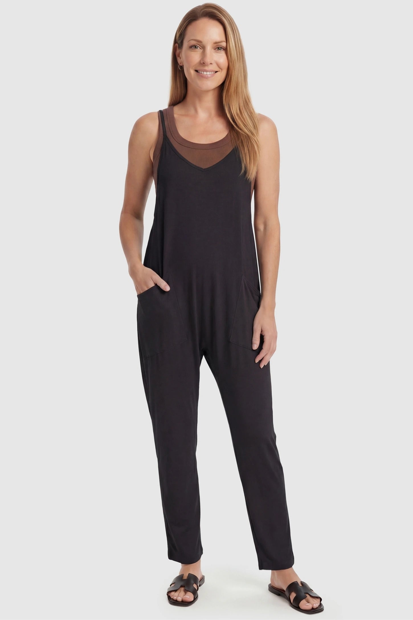 Adjustable Strap Pocketed Relaxed Maternity Jumpsuit Adjustable Strap Relaxed Maternity Jumpsuit in Black featuring a loose fit and functional pockets on a non-pregnant model.
