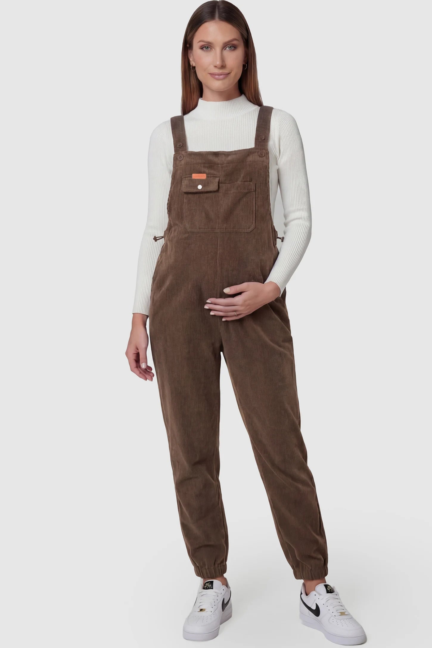Adjustable strap loose fit maternity overalls in brown featuring wide leg design on a pregnant model
