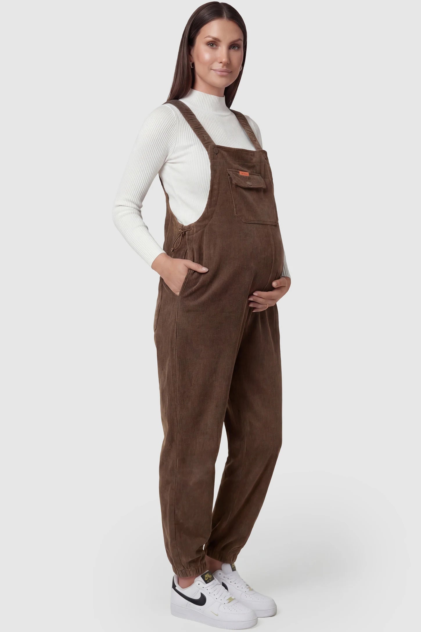 Adjustable Strap Loose Fit Maternity Overalls Adjustable strap loose fit maternity overalls in brown featuring wide leg design on a pregnant model