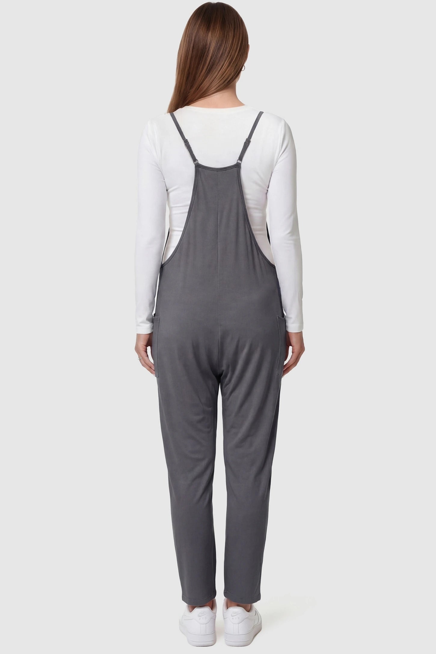 Adjustable Strap Pocketed Relaxed Maternity Jumpsuit Adjustable Strap Relaxed Maternity Jumpsuit in Dark Gray featuring a loose fit on a pregnant model.