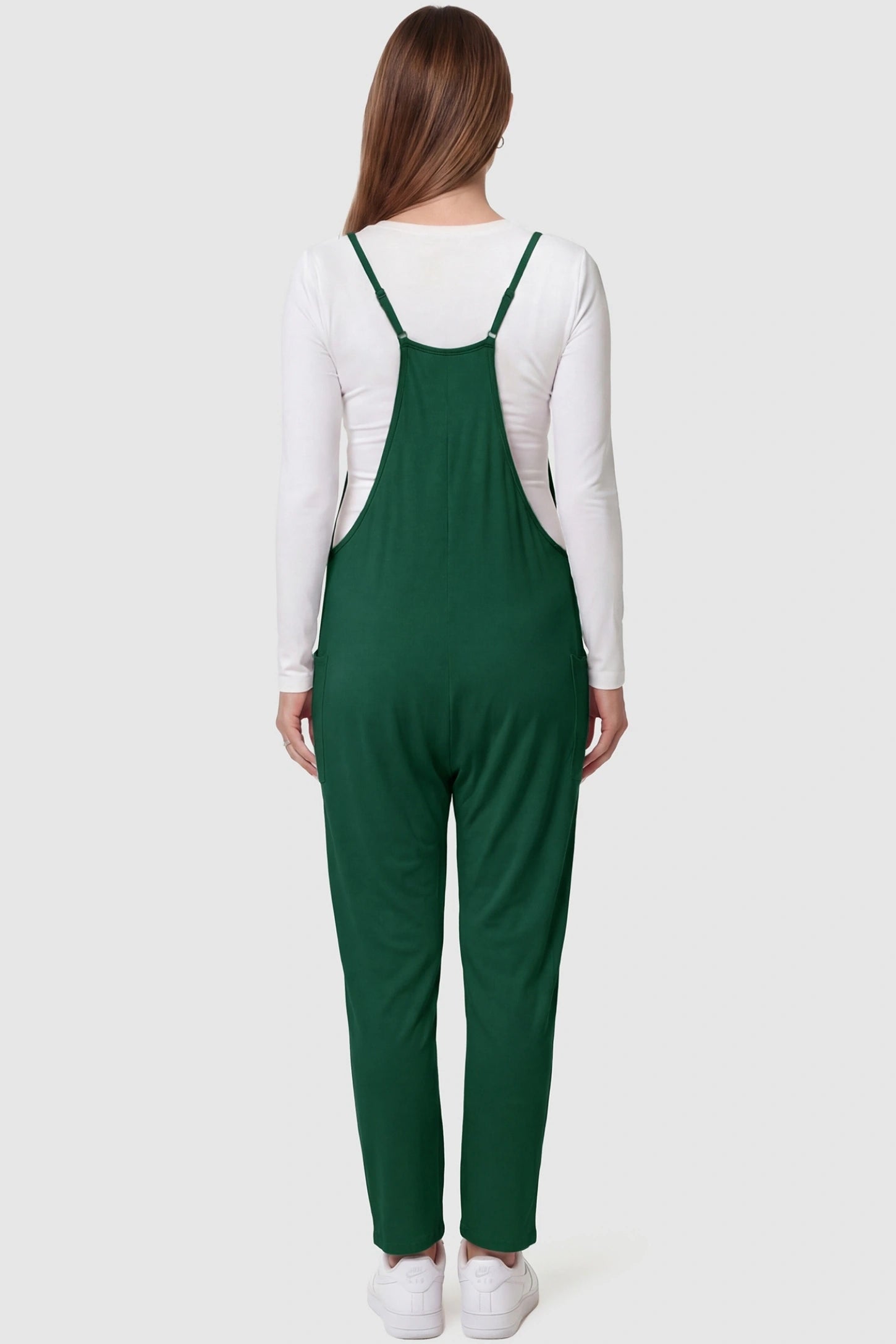 Adjustable Strap Pocketed Relaxed Maternity Jumpsuit Adjustable Strap Relaxed Maternity Jumpsuit in Dark Green featuring a loose fit on a pregnant model.