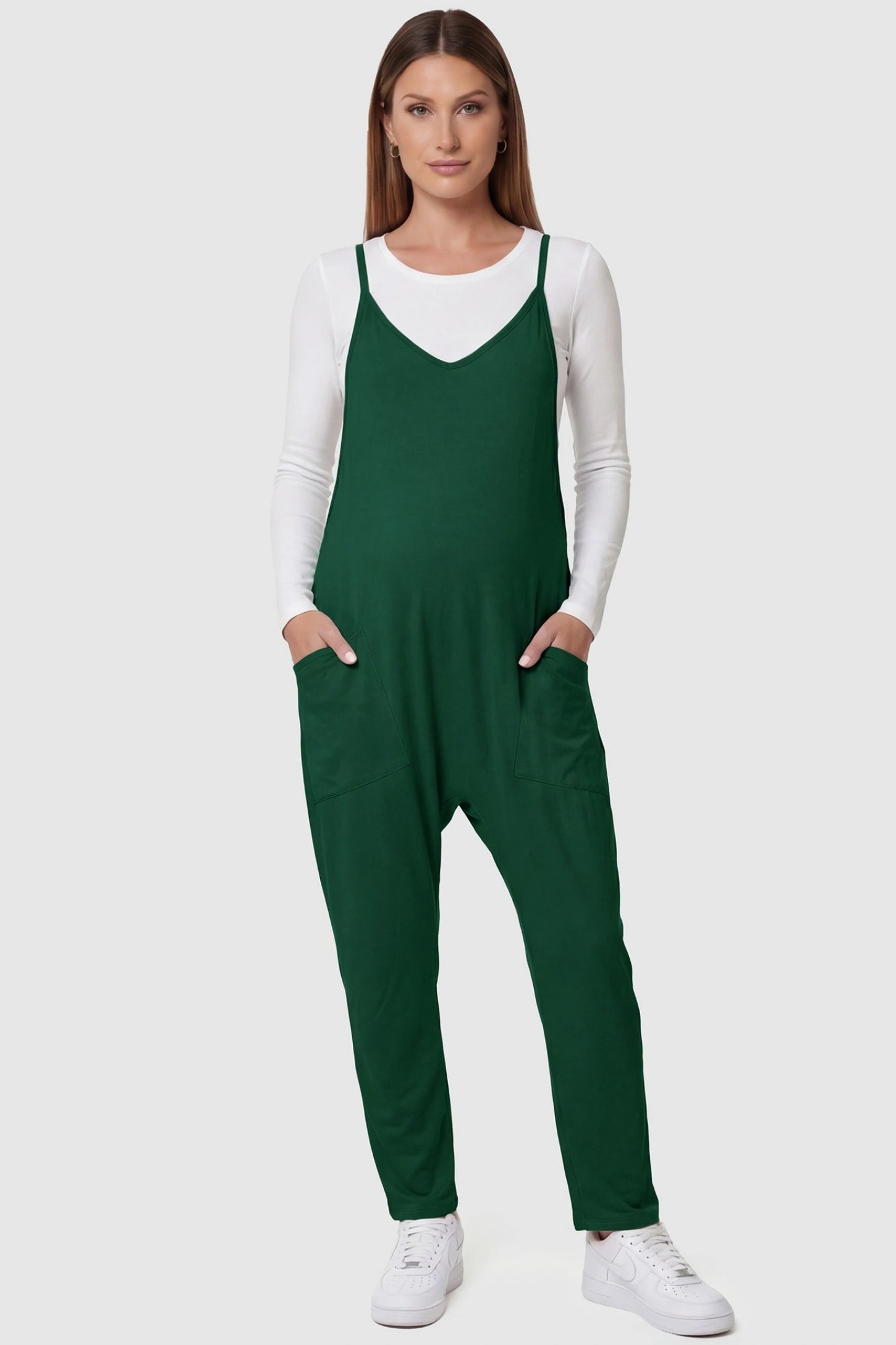 Adjustable Strap Pocketed Relaxed Maternity Jumpsuit Adjustable Strap Relaxed Maternity Jumpsuit in Dark Green featuring a loose fit and functional pockets on a pregnant model.