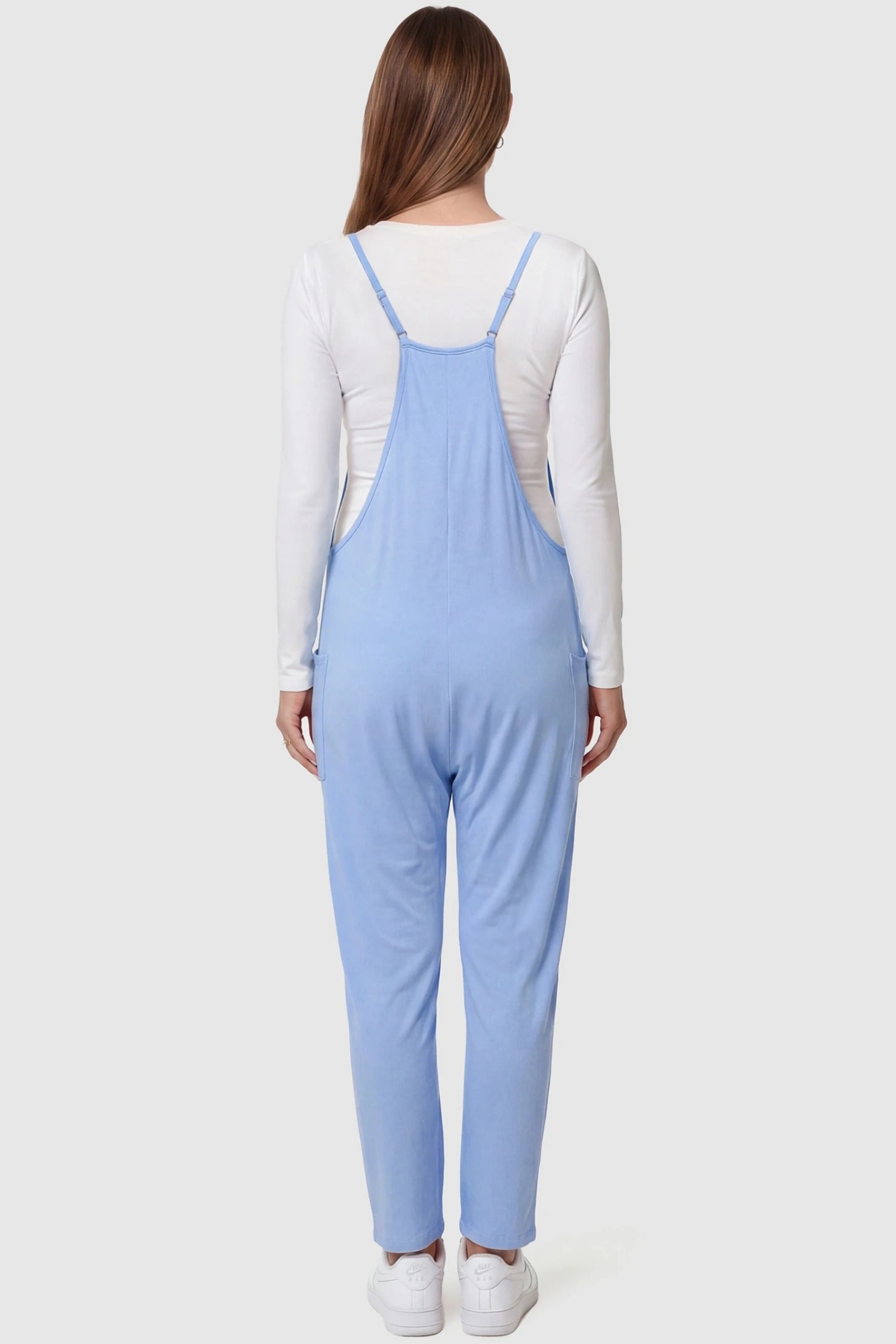 Adjustable Strap Pocketed Relaxed Maternity Jumpsuit Adjustable Strap Relaxed Maternity Jumpsuit in Light Blue featuring a loose fit on a pregnant model.