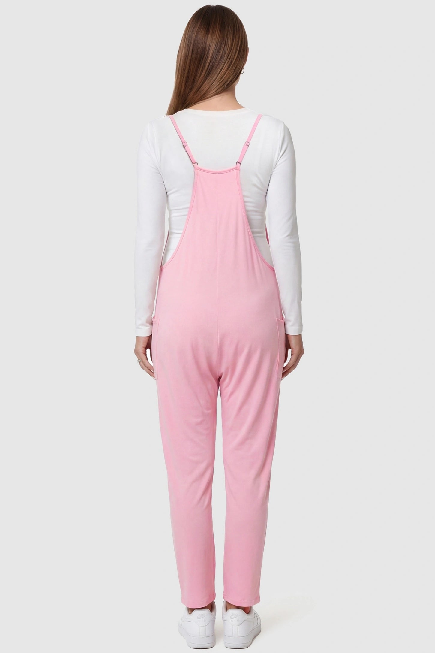 Adjustable Strap Pocketed Relaxed Maternity Jumpsuit Adjustable Strap Relaxed Maternity Jumpsuit in Pink featuring a loose fit on a pregnant model.