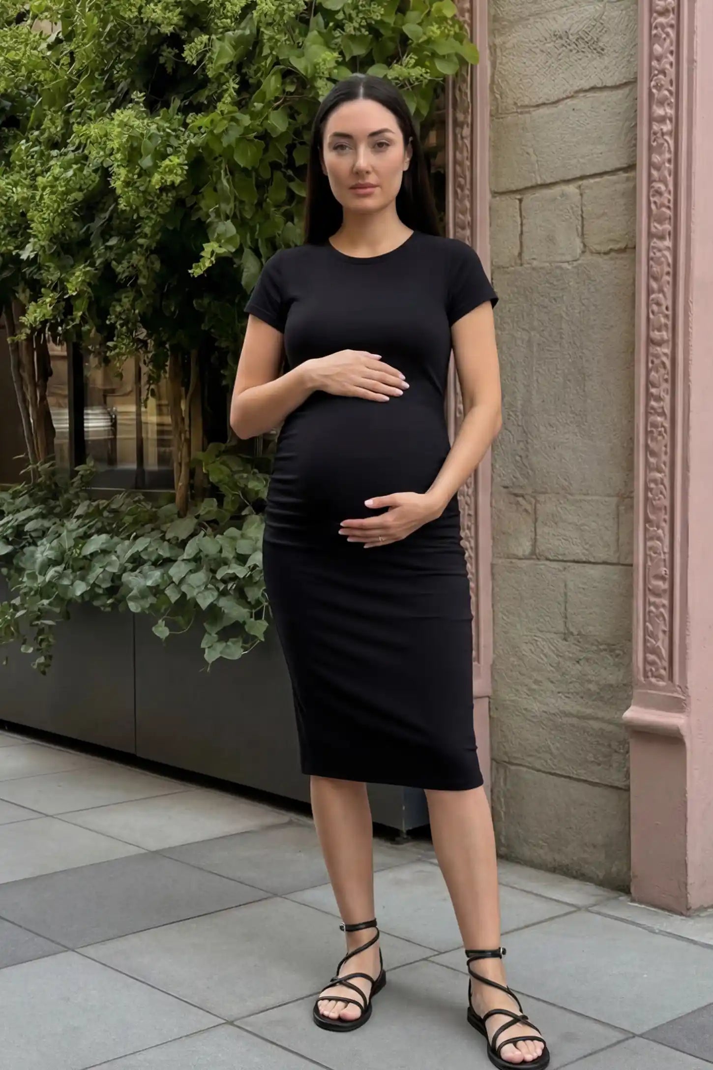 Basic round neck maternity midi dress in black with classic round neckline and side ruching, editorial lifestyle view