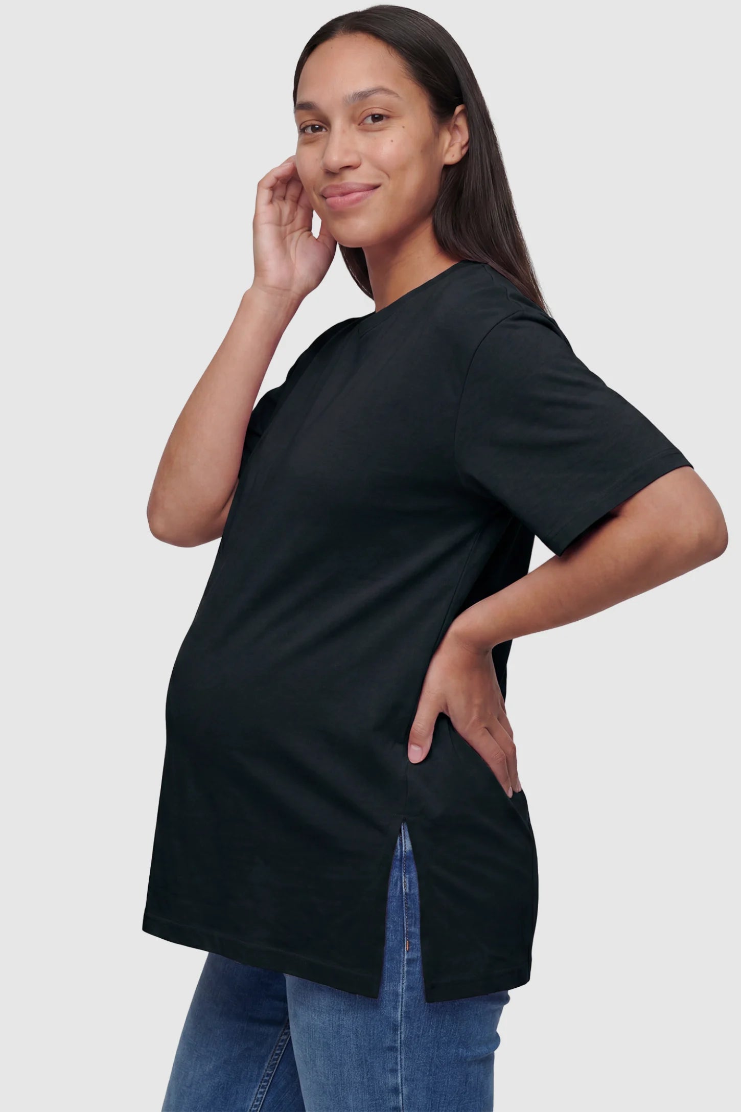 Basic one-sided slit short sleeve maternity top in black with one-sided slit, side view on pregnant model