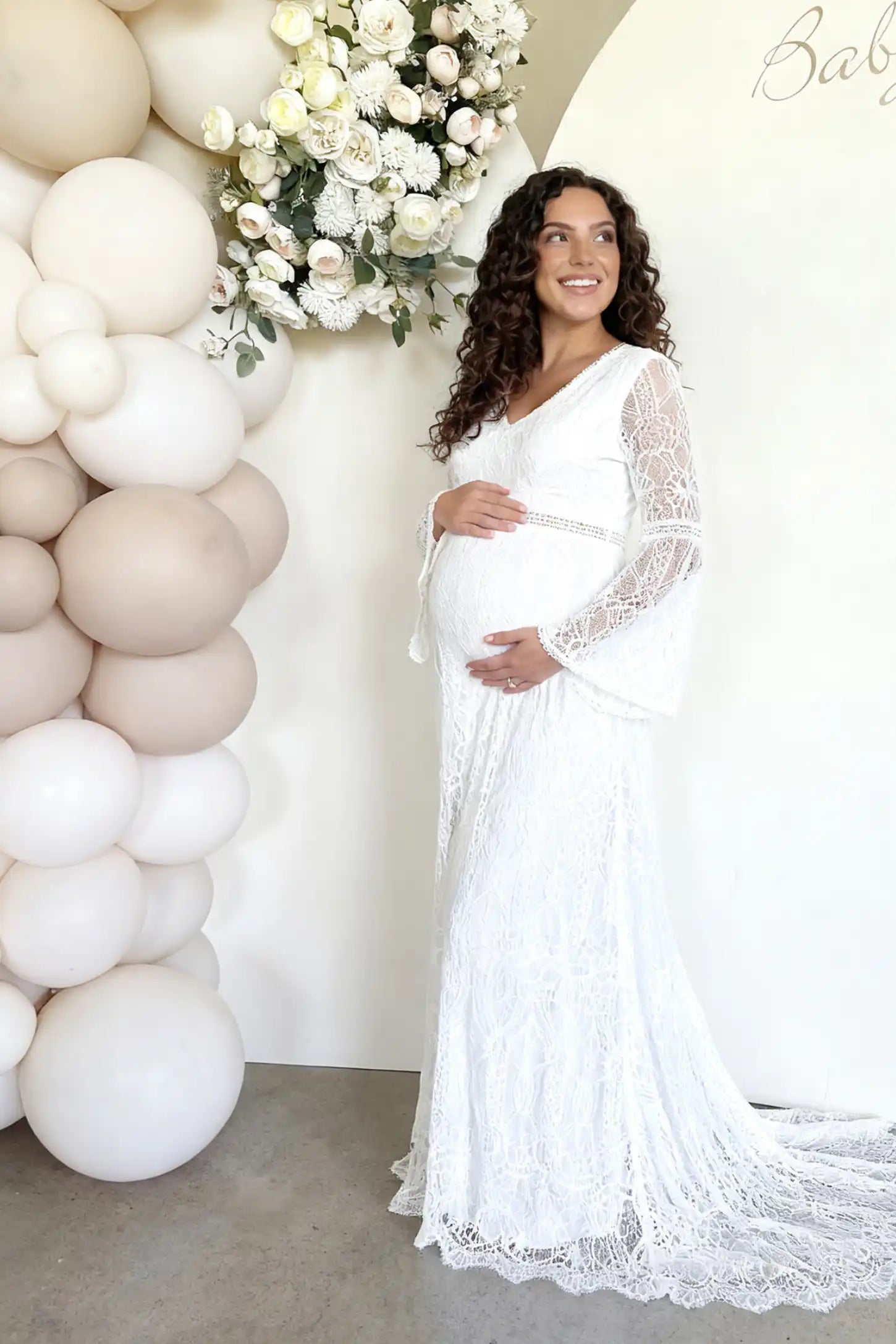Lace Bell-Sleeve Maternity Dress Lace Bell Sleeve Bridal Maternity Gown in white featuring scalloped lace hem and flowy back train on a pregnant model.