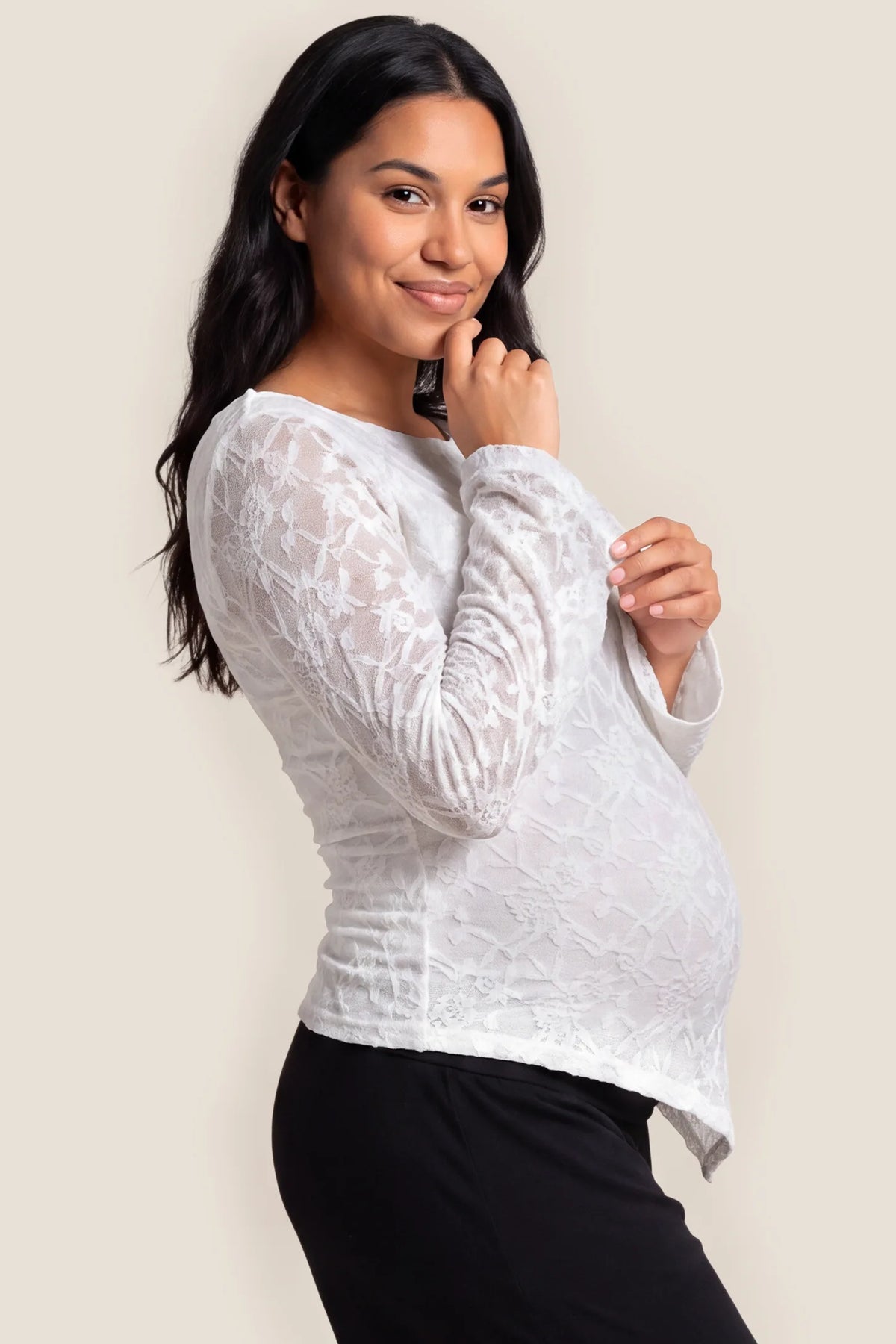 Bell Sleeve Lace Maternity Top in White featuring flexible maternity belly fit, ruched waist gathering, and elegant flared lace sleeves on a pregnant model, studio side view.