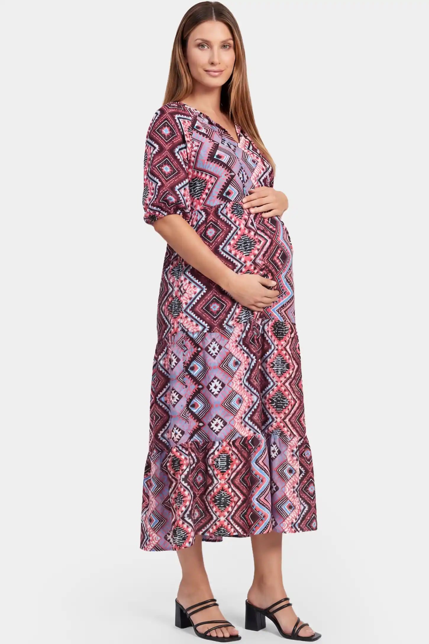 Bohemian print V-neck A-line maxi maternity dress in red featuring high-waisted A-line design in side view on a pregnant model