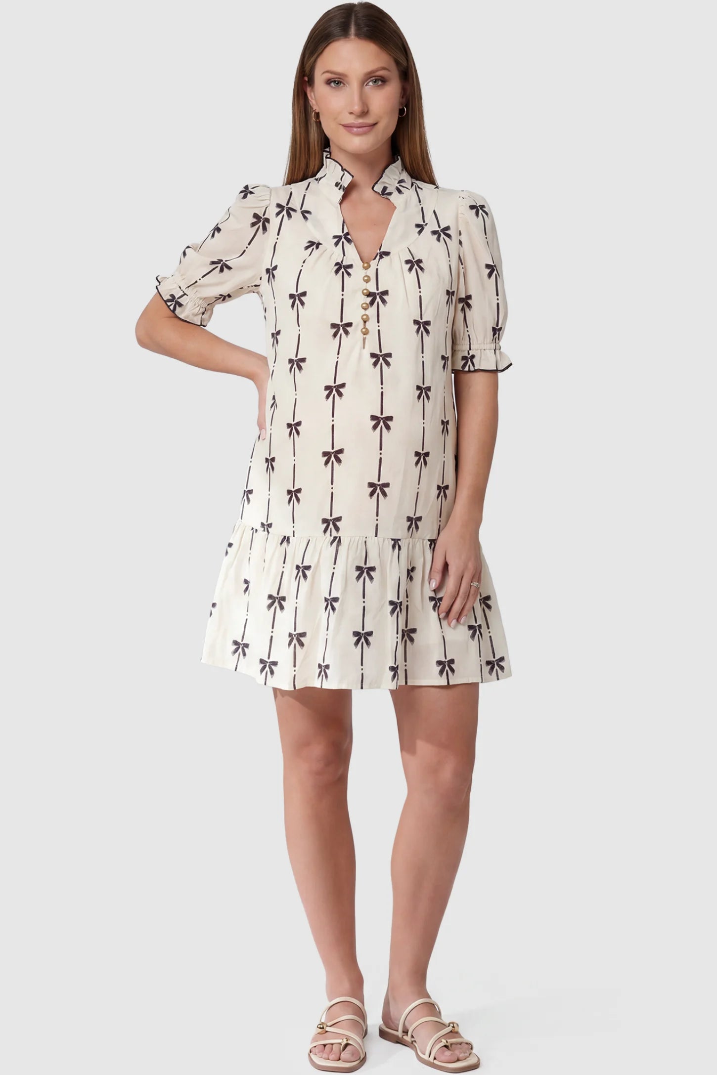Bowknot print button-up neck maternity short dress in beige with bowknot print detail, front view on pregnant model