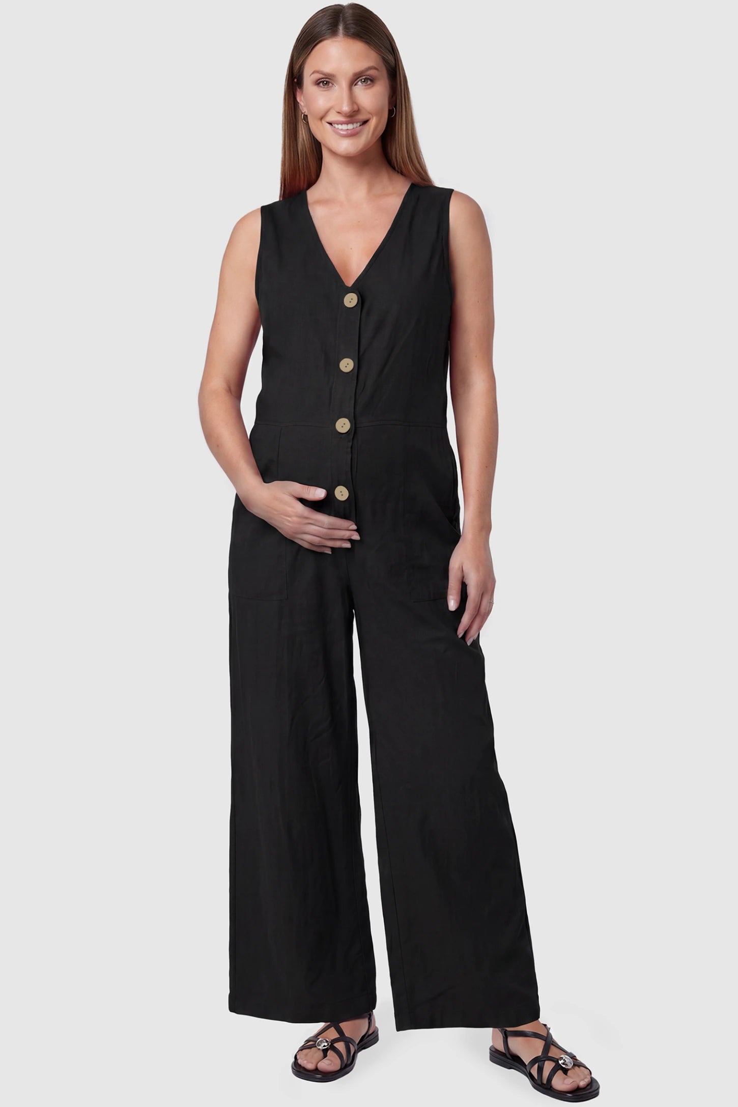 Wide-Leg V-Neck Button-Front Maternity Jumpsuit Wide-leg V-neck button-front maternity jumpsuit in black with sleeveless V-neckline and button-front detail, front view on pregnant model