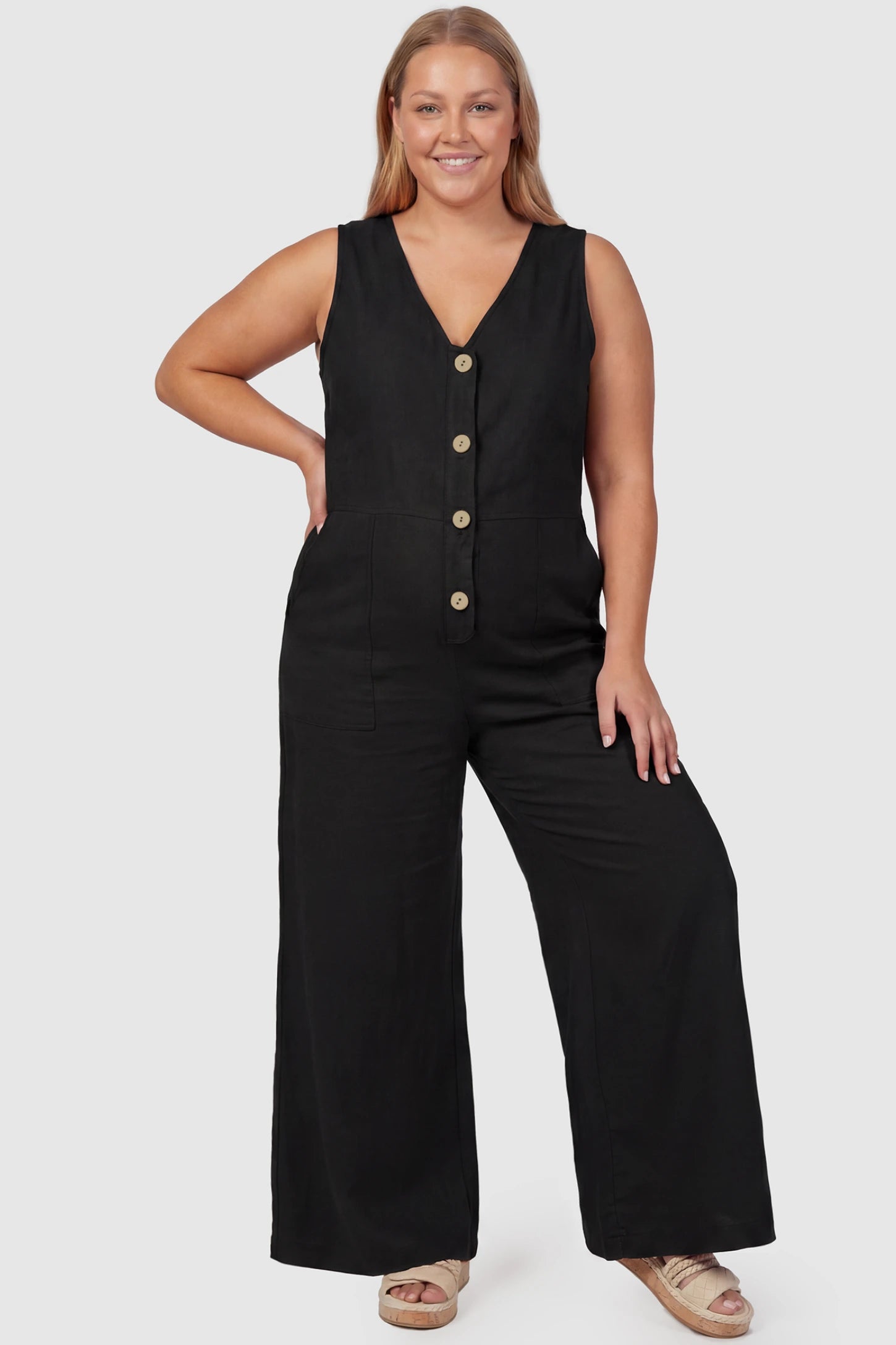 Wide-Leg V-Neck Button-Front Maternity Jumpsuit Wide-leg V-neck button-front maternity jumpsuit in black with sleeveless V-neckline and button-front detail, front view on plus-size model