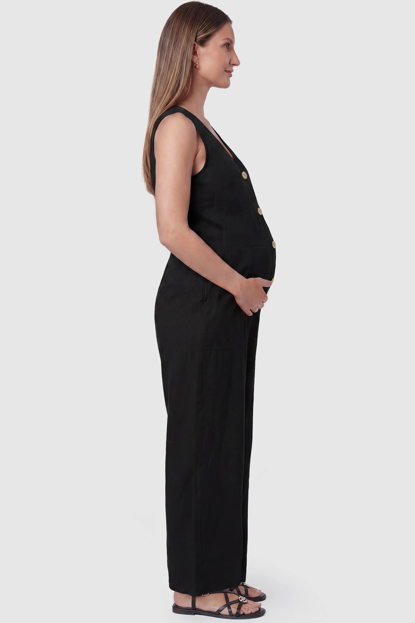 Wide-Leg V-Neck Button-Front Maternity Jumpsuit Wide-leg V-neck button-front maternity jumpsuit in black with sleeveless cut, side view on pregnant model