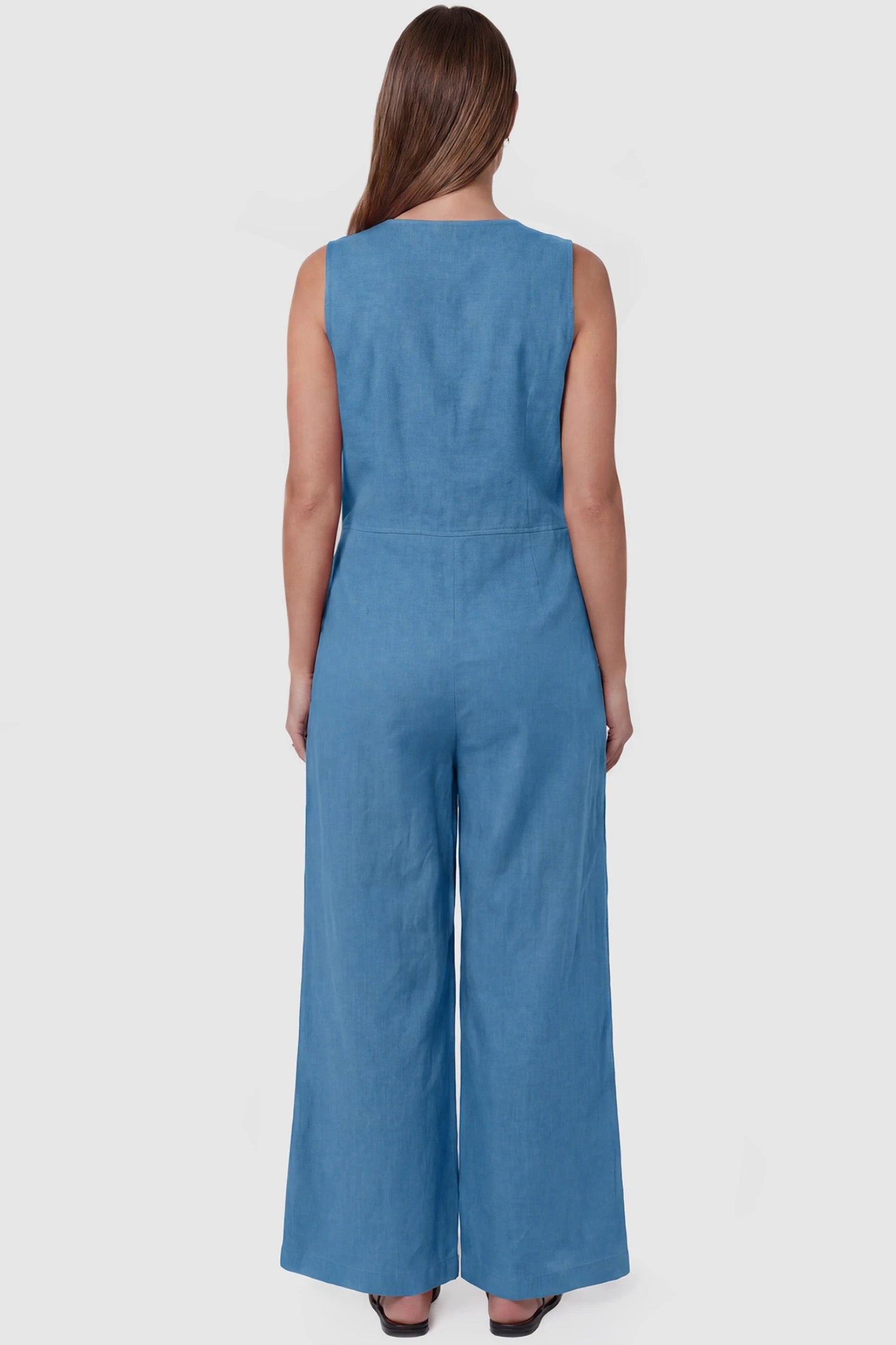 Wide-Leg V-Neck Button-Front Maternity Jumpsuit Wide-leg V-neck button-front maternity jumpsuit in blue with sleeveless cut, back view on pregnant model