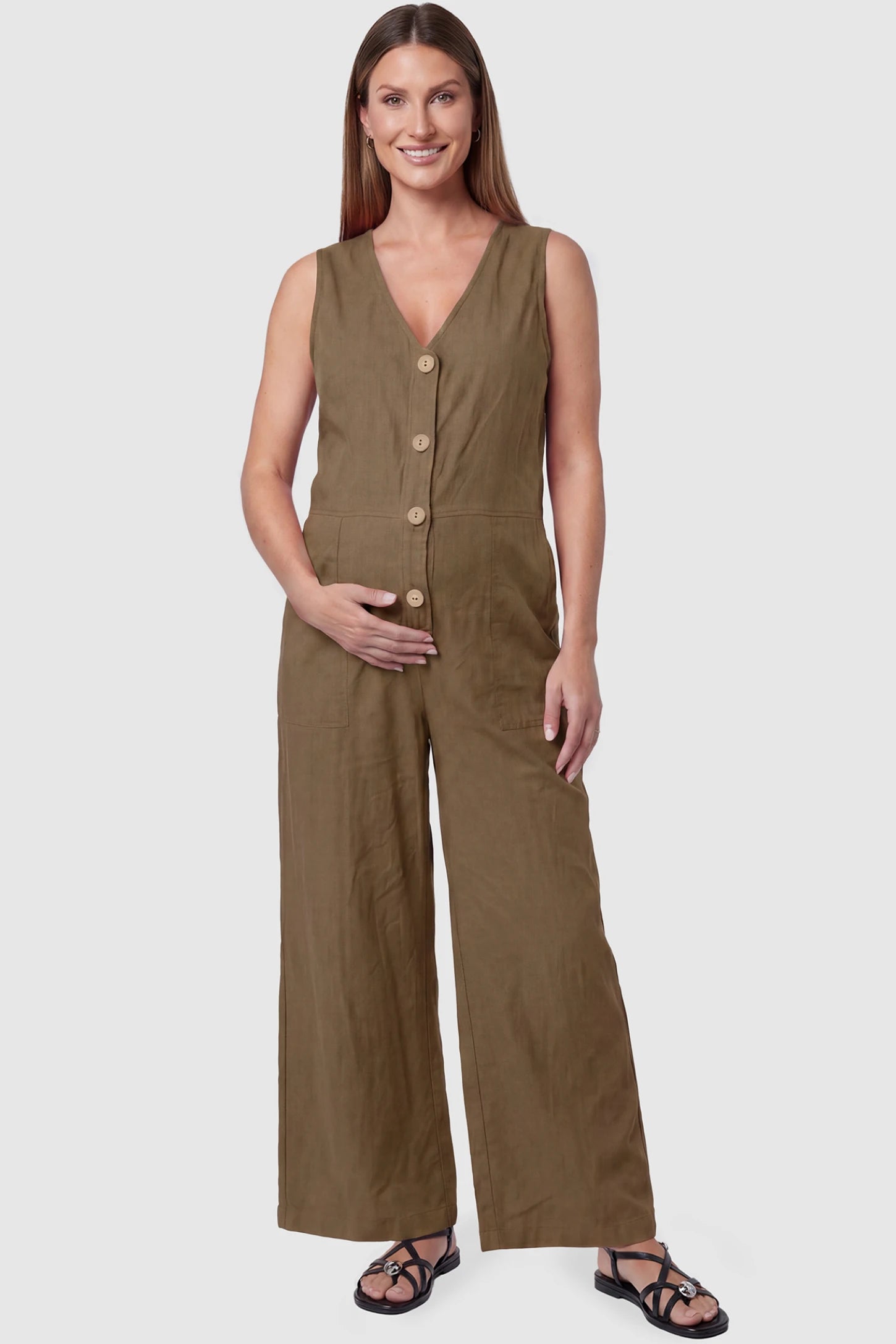 Wide-Leg V-Neck Button-Front Maternity Jumpsuit Wide-leg V-neck button-front maternity jumpsuit in brown with sleeveless V-neckline and button-front detail, front view on pregnant model