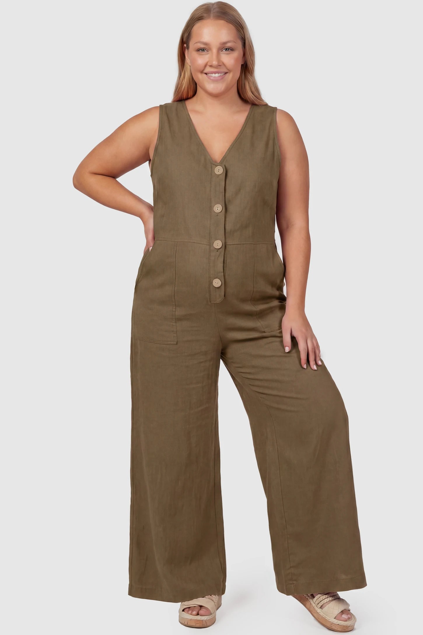 Wide-Leg V-Neck Button-Front Maternity Jumpsuit Wide-leg V-neck button-front maternity jumpsuit in brown with sleeveless V-neckline and button-front detail, front view on plus-size model
