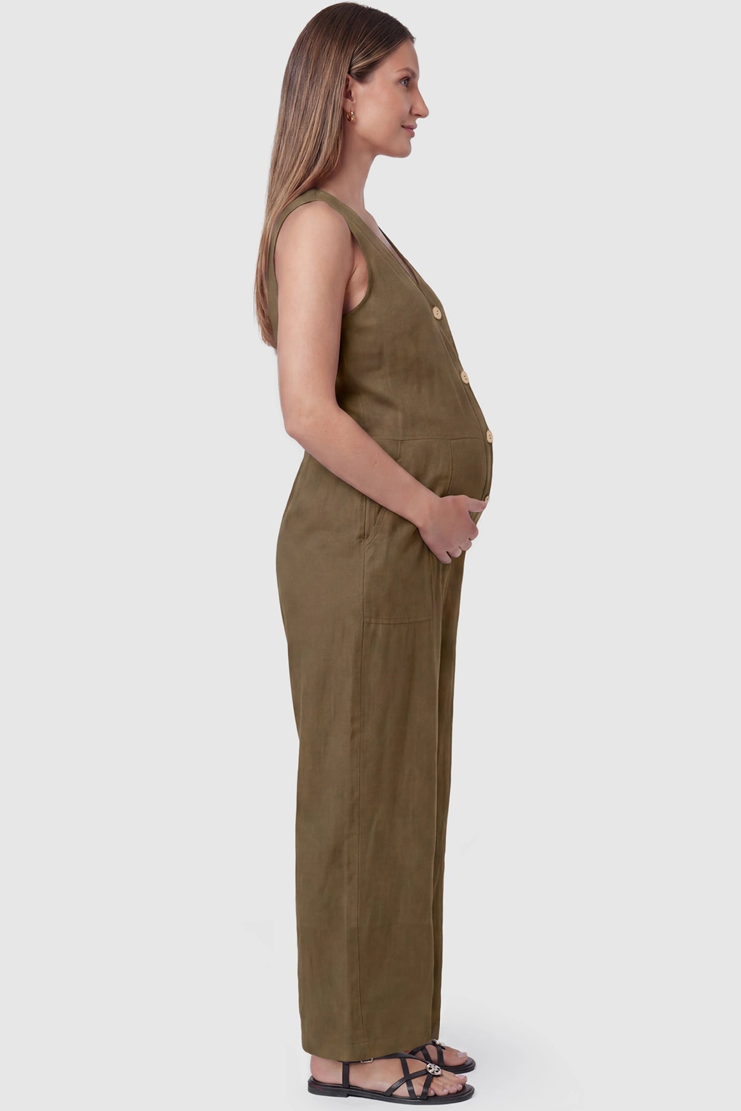 Wide-Leg V-Neck Button-Front Maternity Jumpsuit Wide-leg V-neck button-front maternity jumpsuit in brown with sleeveless cut, side view on pregnant model