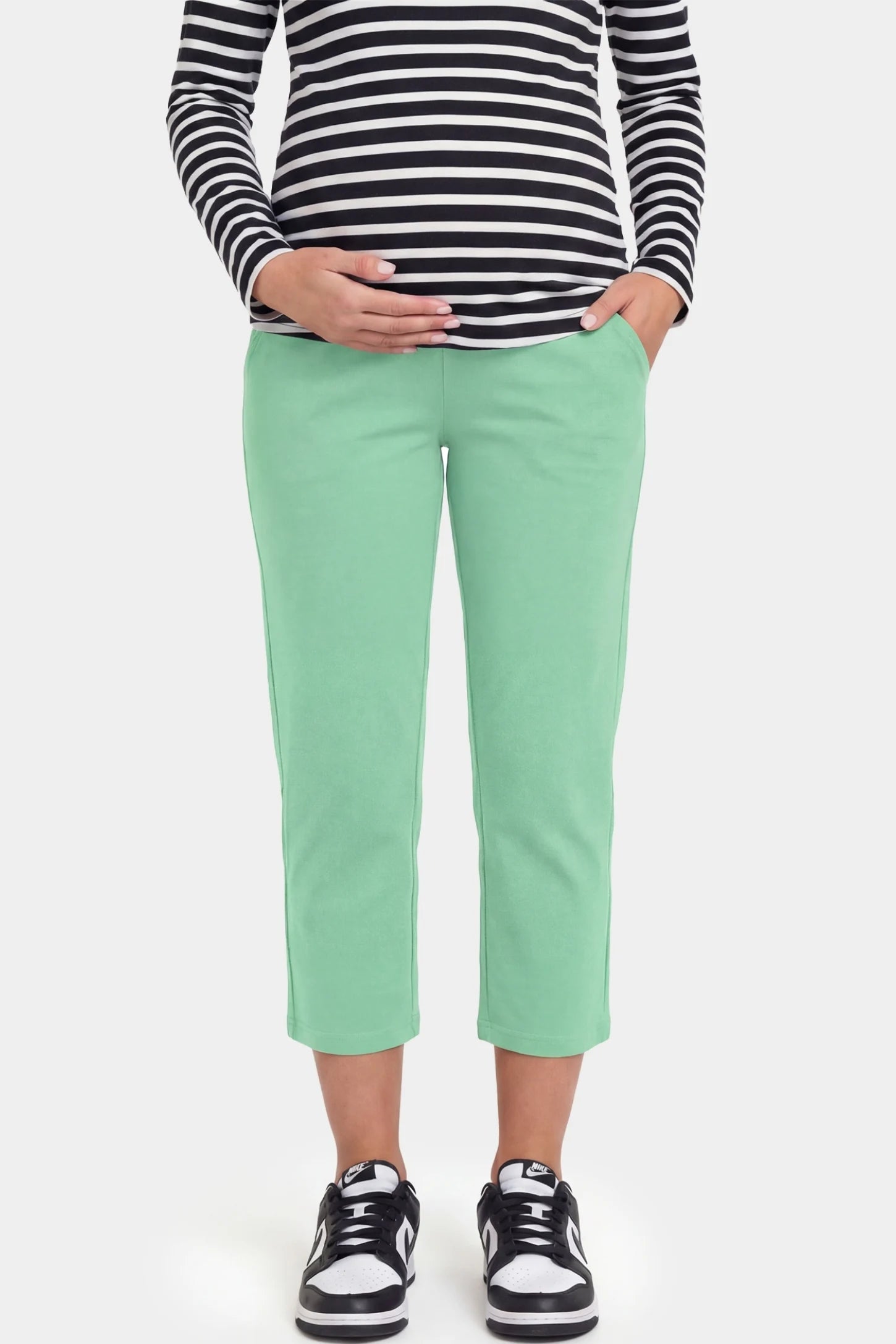 High-Waist Belly Support Loose-Fit Capri Maternity Pants High-waist belly support loose-fit capri maternity pants in emerald green with functional side pockets, front view on pregnant model