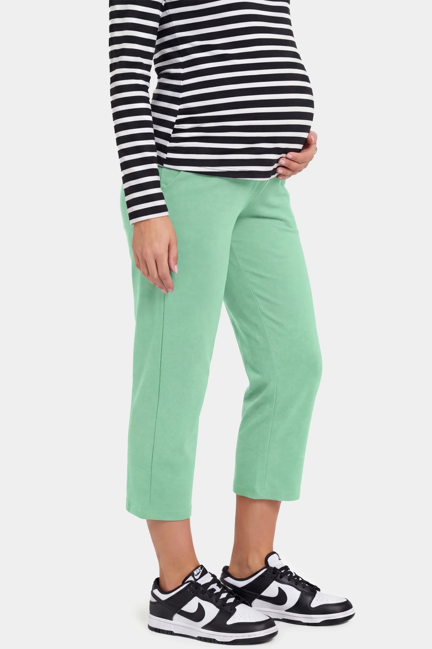 High-Waist Belly Support Loose-Fit Capri Maternity Pants High-waist belly support loose-fit capri maternity pants in emerald green with cropped length, side view on pregnant model