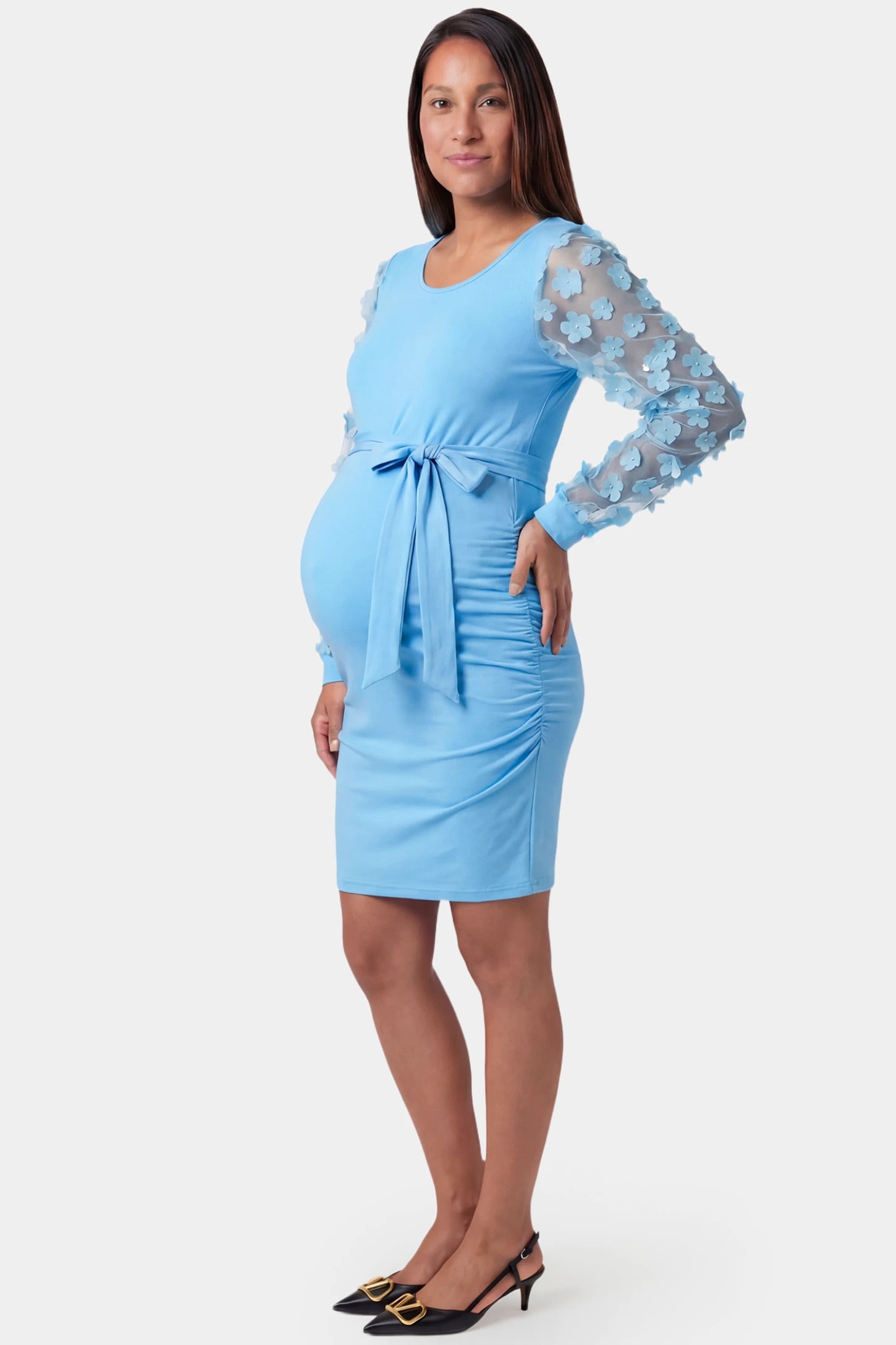 Sheer Long-Sleeve Tie-Waist Short Maternity Dress Sheer long-sleeve tie-waist short maternity dress in light blue featuring side ruching detail in side view on a pregnant model