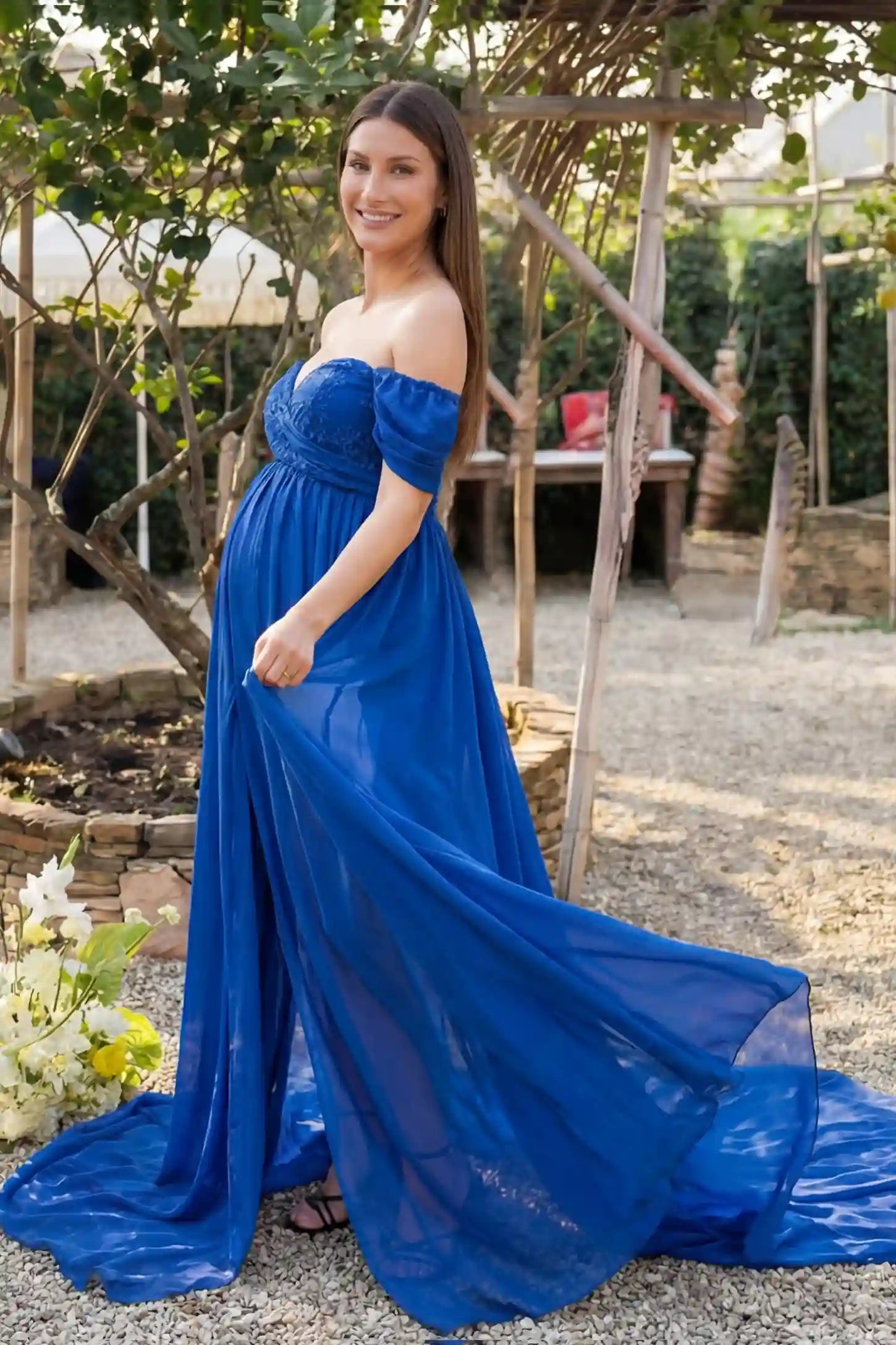 Chiffon Split-Front Maxi Maternity Photoshoot Gown Chiffon Split-Front Maxi Maternity Photoshoot Dress in Blue featuring a semi-sheer split skirt on a side-profile pregnant model.